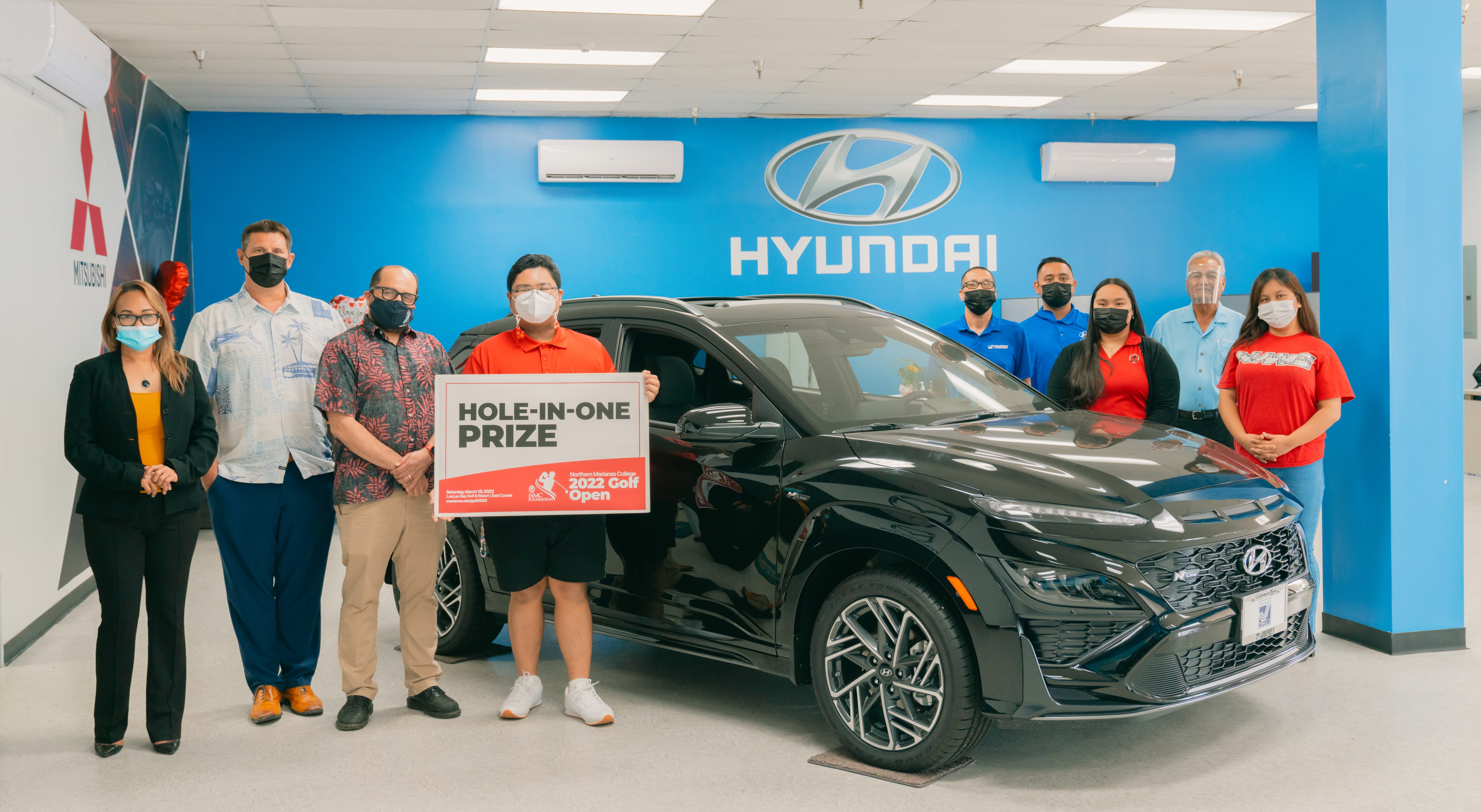 Triple J Motors is offering a brand new 2022 Hyundai Kona N-Line as a hole-in-one prize in the upcoming 17th Annual NMC Foundation Golf Tournament. In photo are NMC students and employees along with NMC President Galvin Deleon Guerrero, EdD, Triple J Motors General Manager Sean Ficke, and Triple J Motors representatives.
