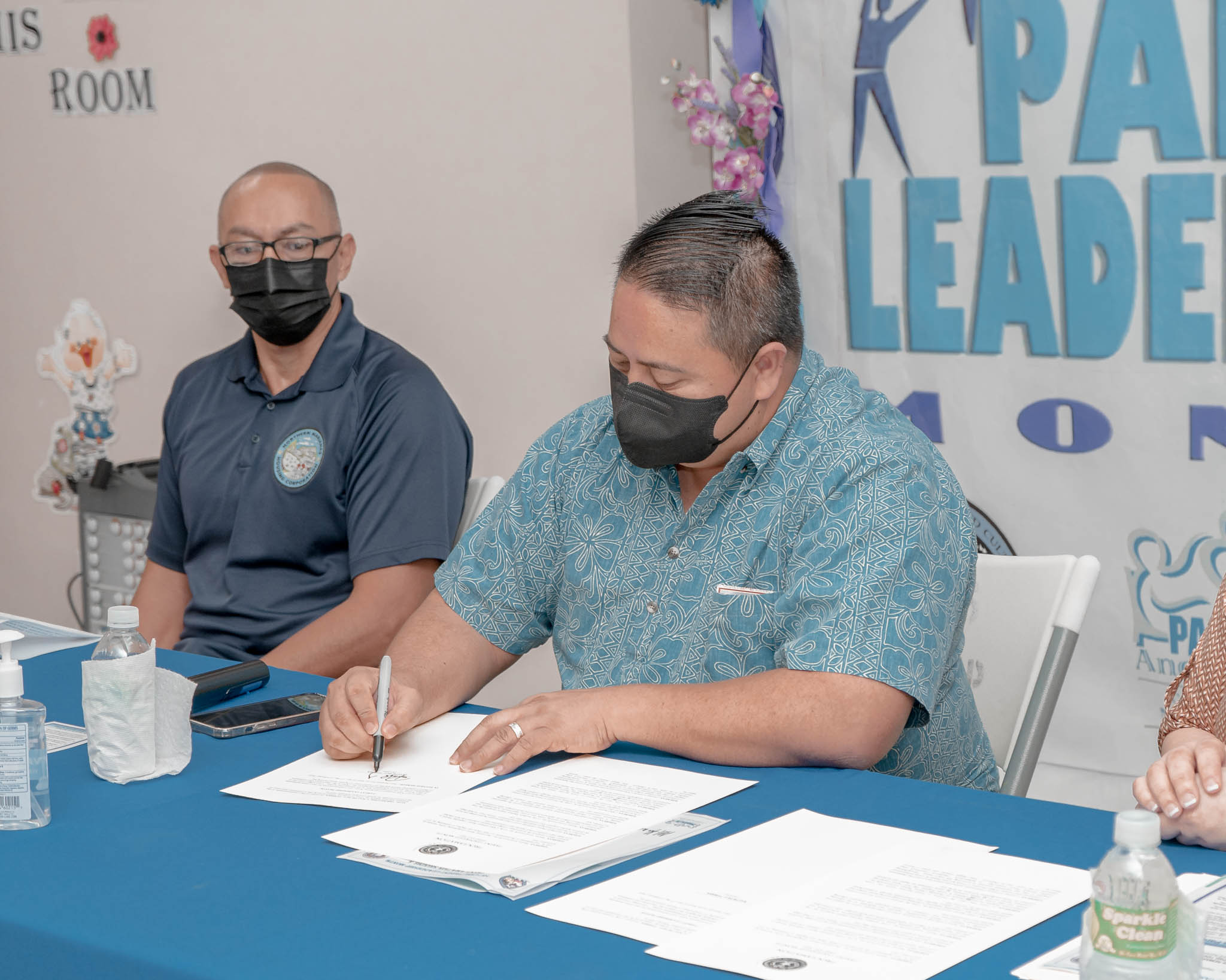 Gov. Ralph DLG Torres signs a proclamation designating February as Parent Leadership Month while Northern Marianas Housing Corp. Corporate Director Jess Palacios, left, looks on at the expanded and rehabilitated Tanapag Youth Center on Tuesday.