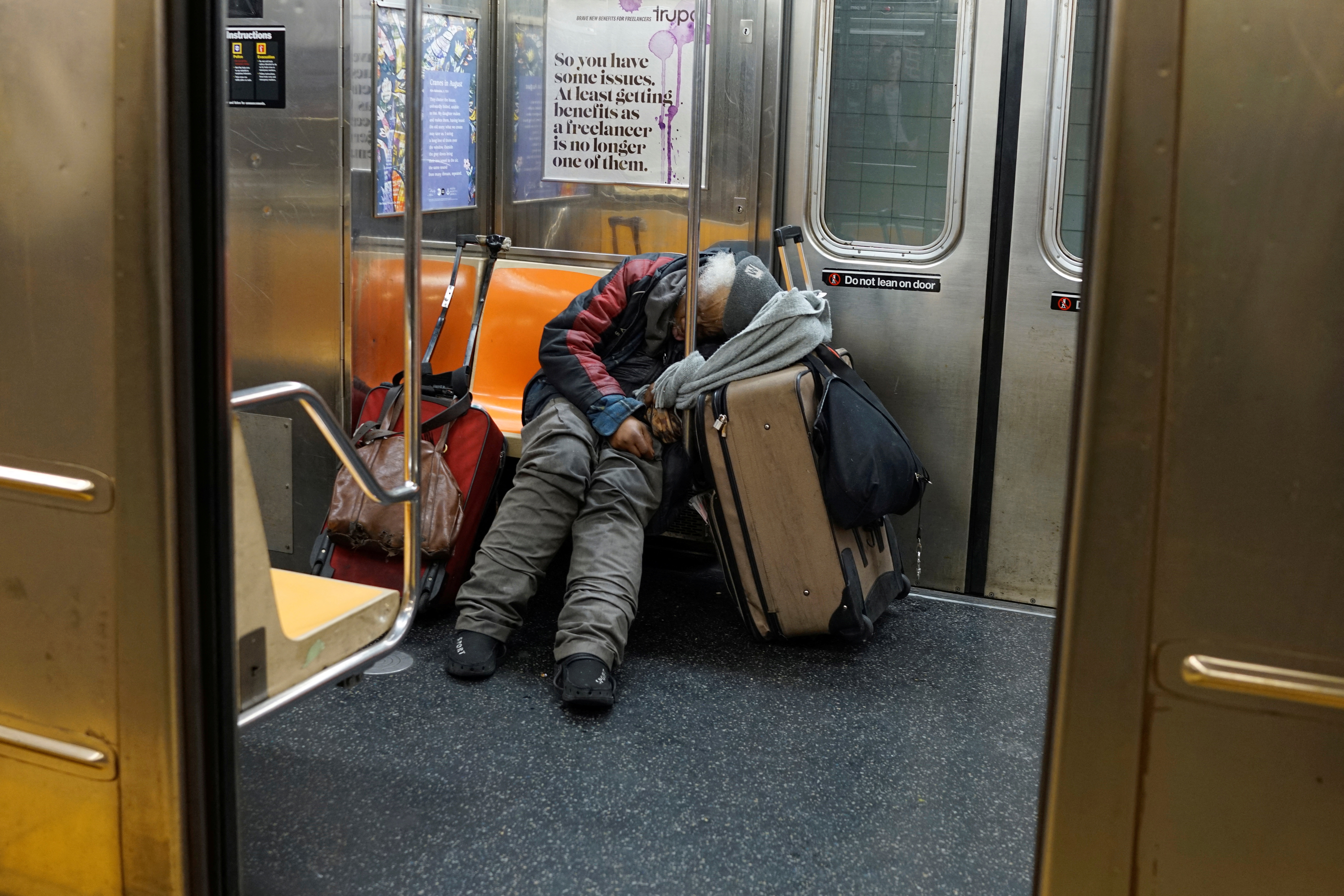 A man sleeps on a New York subway train as the outbreak of the coronavirus continues in New York on April 13, 2020.
