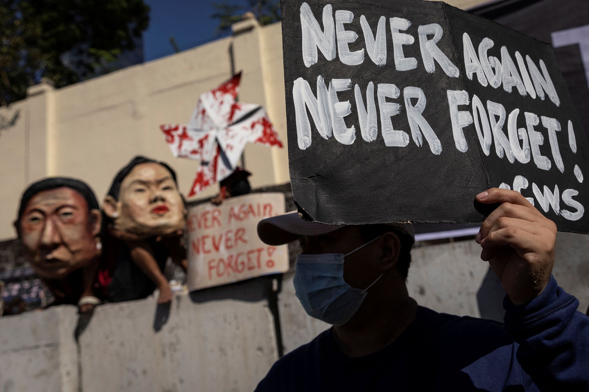 A Filipino raises a placard during a rally marking the anniversary of the 1986's People Power Revolution that overthrew the late dictator Ferdinand Marcos, near the EDSA People Power monument in Quezon City, Metro Manila, Feb. 25, 2022.