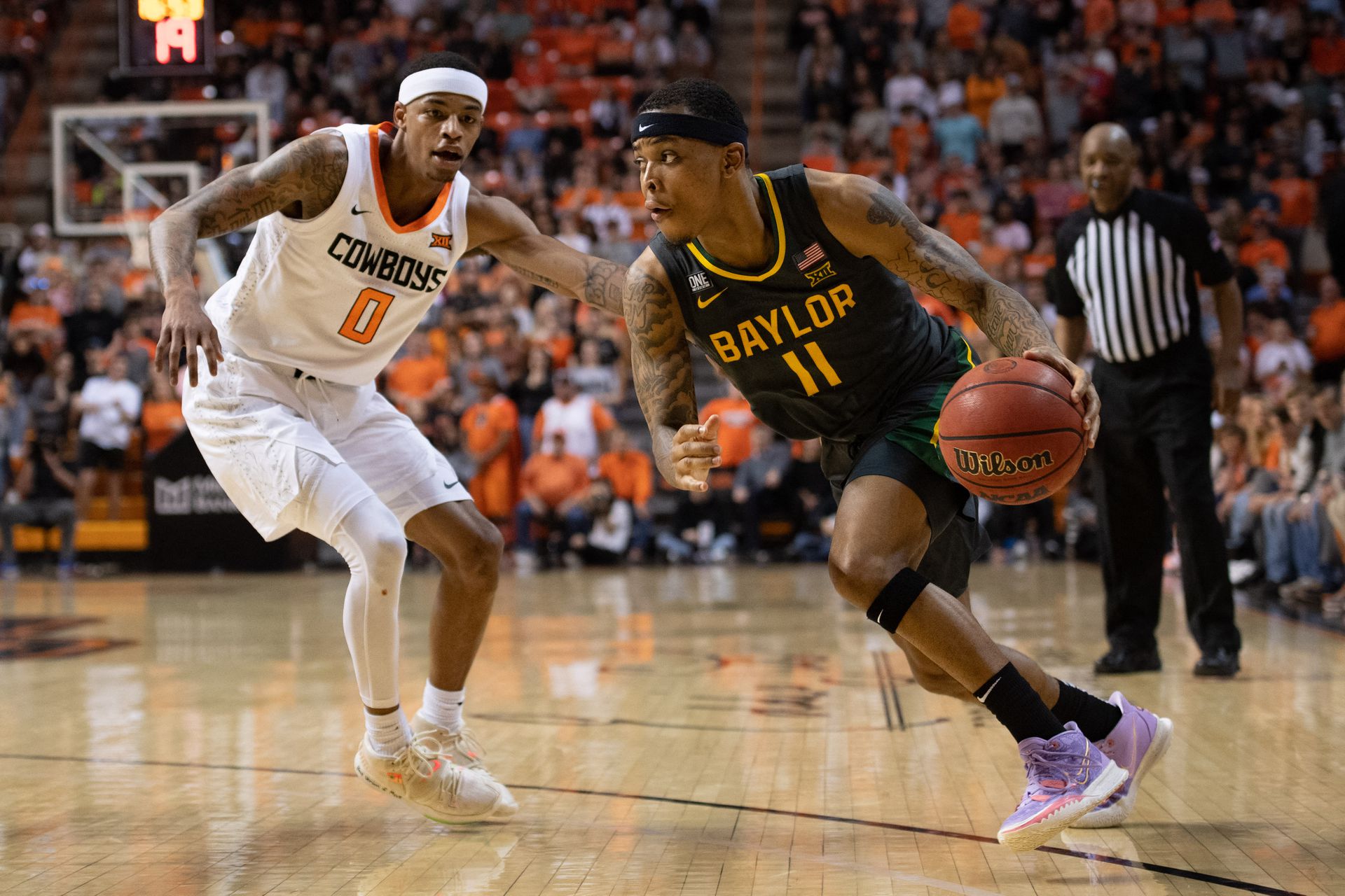 Baylor Bears guard James Akinjo (11) controls the ball against Oklahoma State Cowboys guard Avery Anderson III (0) during the second half at Gallagher-Iba Arena in Stillwater, Oklahoma on Feb. 21, 2022.