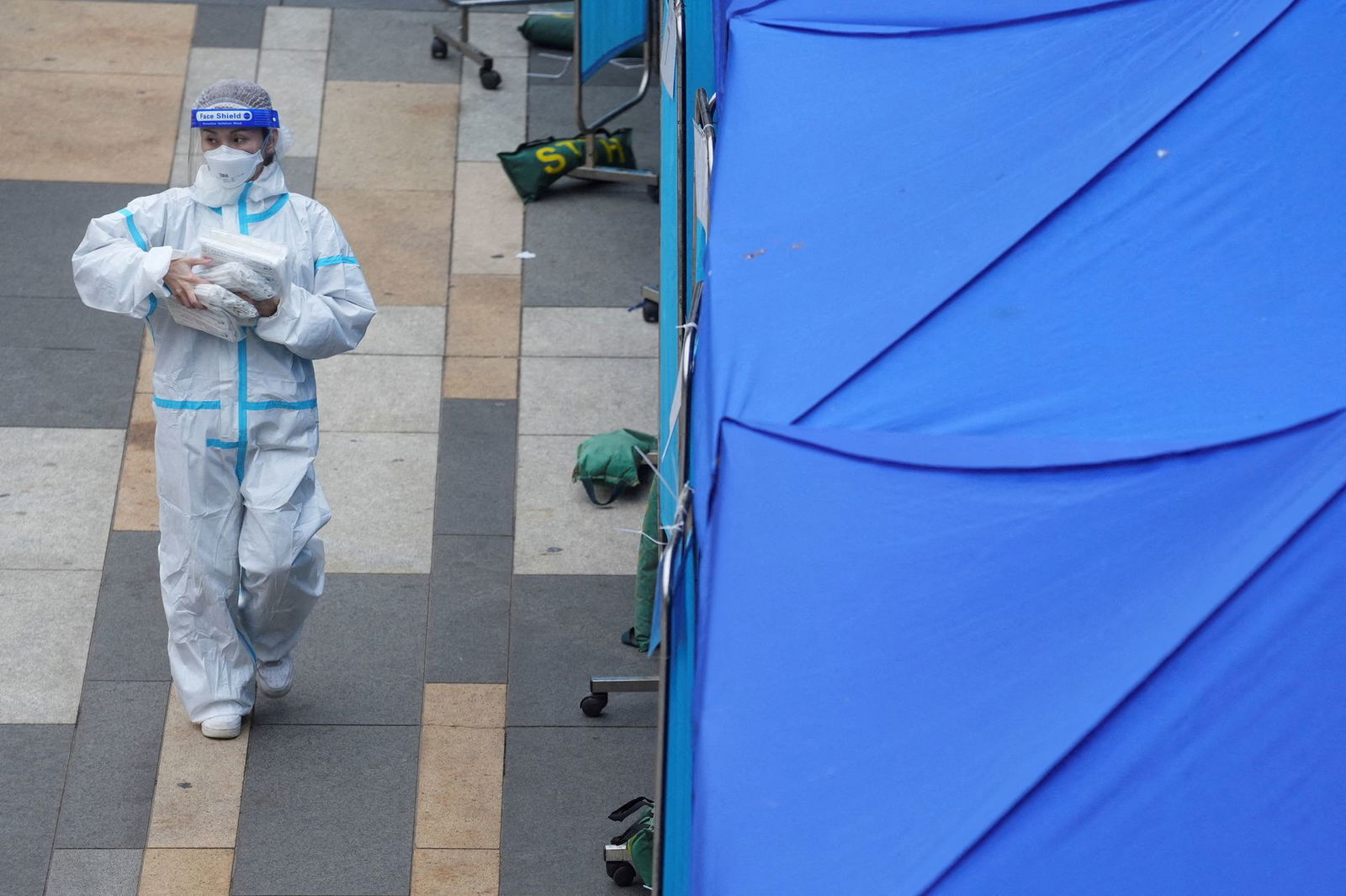 A medical worker walks past a makeshift testing center for the coronavirus disease following the outbreak, outside a shopping mall at Sha Tin district, in Hong Kong,  Feb. 7, 2022.