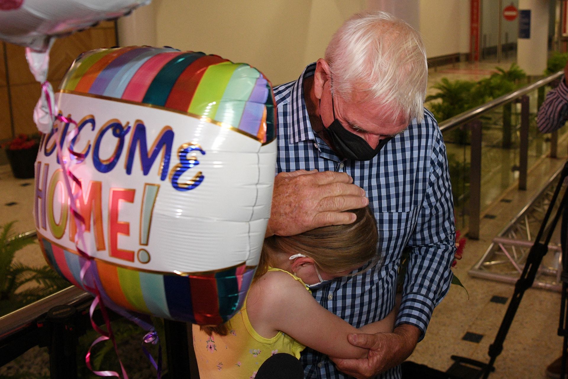 Charlotte Roempke, 8, welcomes her grandfather Bernie Edmonds as he arrives at Sydney International Airport after Australia reopened its international borders to travelers vaccinated against the coronavirus disease in Sydney, Australia on Feb. 21, 2022.