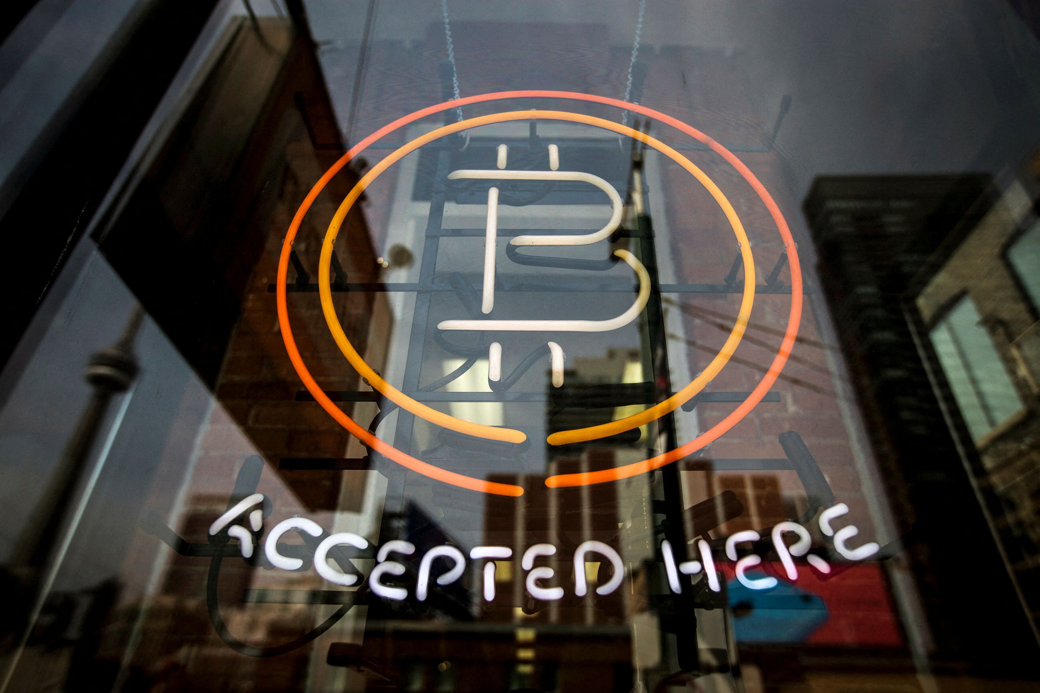 A bitcoin sign is seen in a window in Toronto, May 8, 2014.