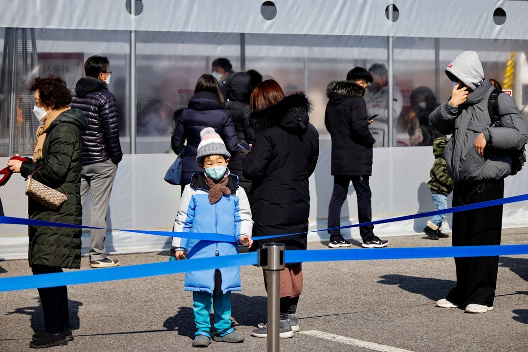 People wait in line to undergo the coronavirus disease test at a temporary testing site set up in Seoul, South Korea, Feb. 16, 2022.