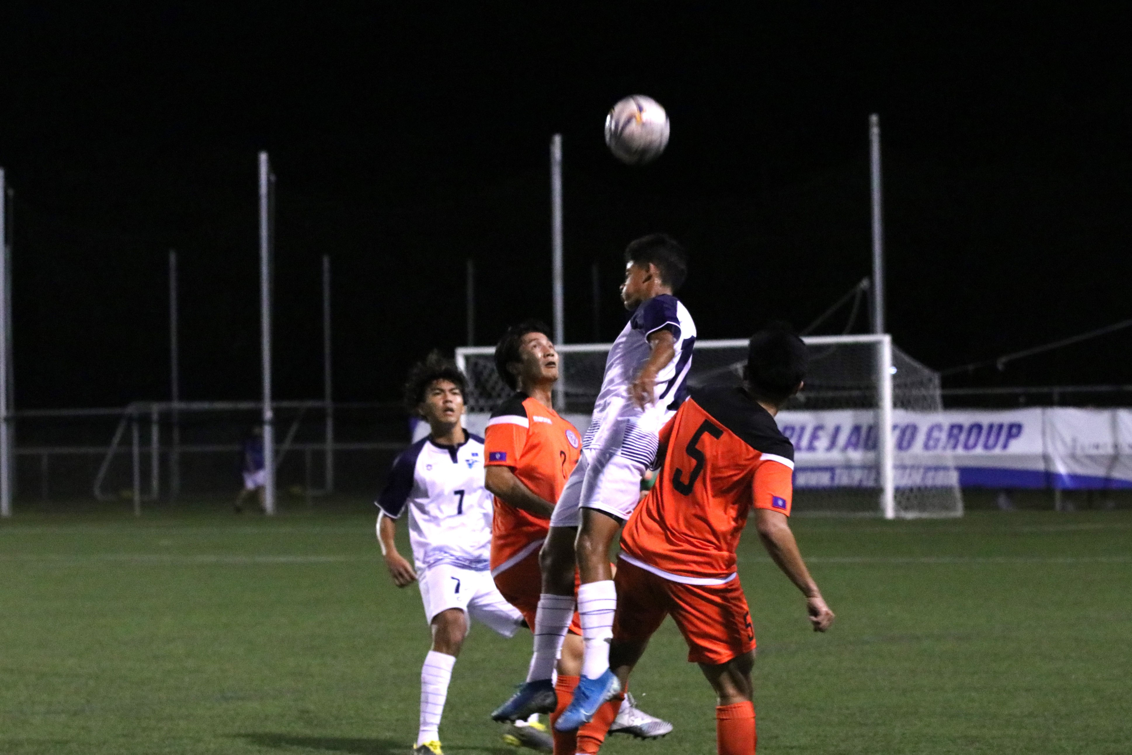 NMI Men's Dev Bachani leaps for the header against a Guam defender  in their second friendly match at the Guam Football Association National Training Center in Dededo.