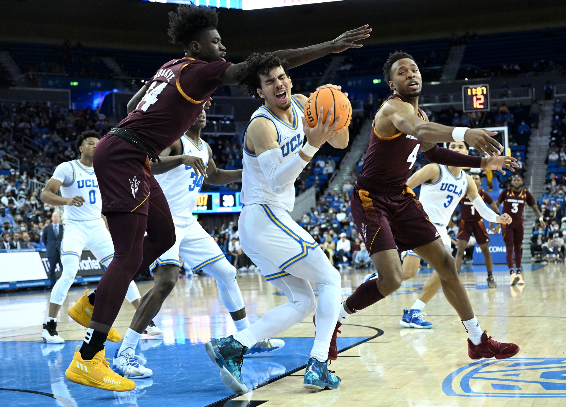 UCLA Bruins guard Jules Bernard (1) grabs a rebound against Arizona State Sun Devils center Enoch Boakye (14) and forward Kimani Lawrence (4) in the second half of the game at Pauley Pavilion presented by Wescom in Los Angeles, California on Feb. 21, 2022.