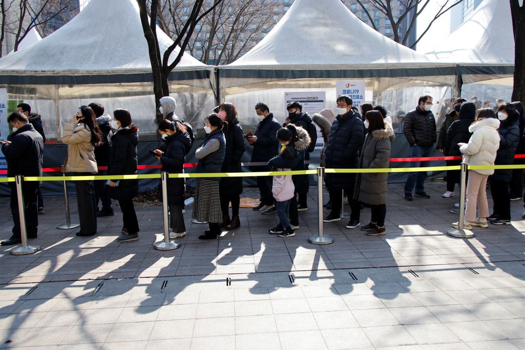 People wait in line to undergo the coronavirus disease test at a temporary testing site set up at City Hall Plaza in Seoul, South Korea, Feb. 10, 2022. 