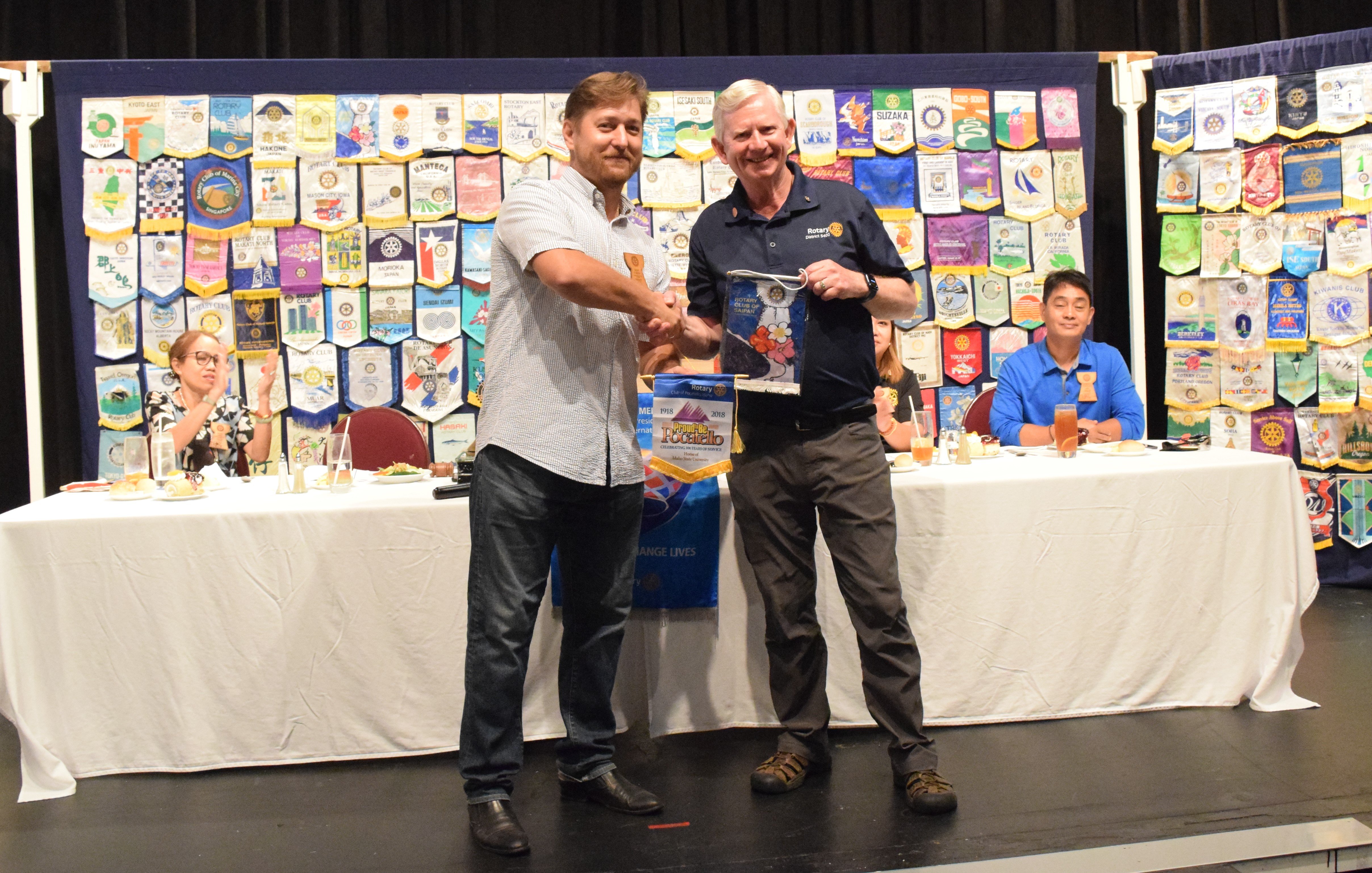 Saipan Rotary Club President Ivan Ilmov and visiting Rotarian Rich Kirkham of Idaho exchange Rotary flags.