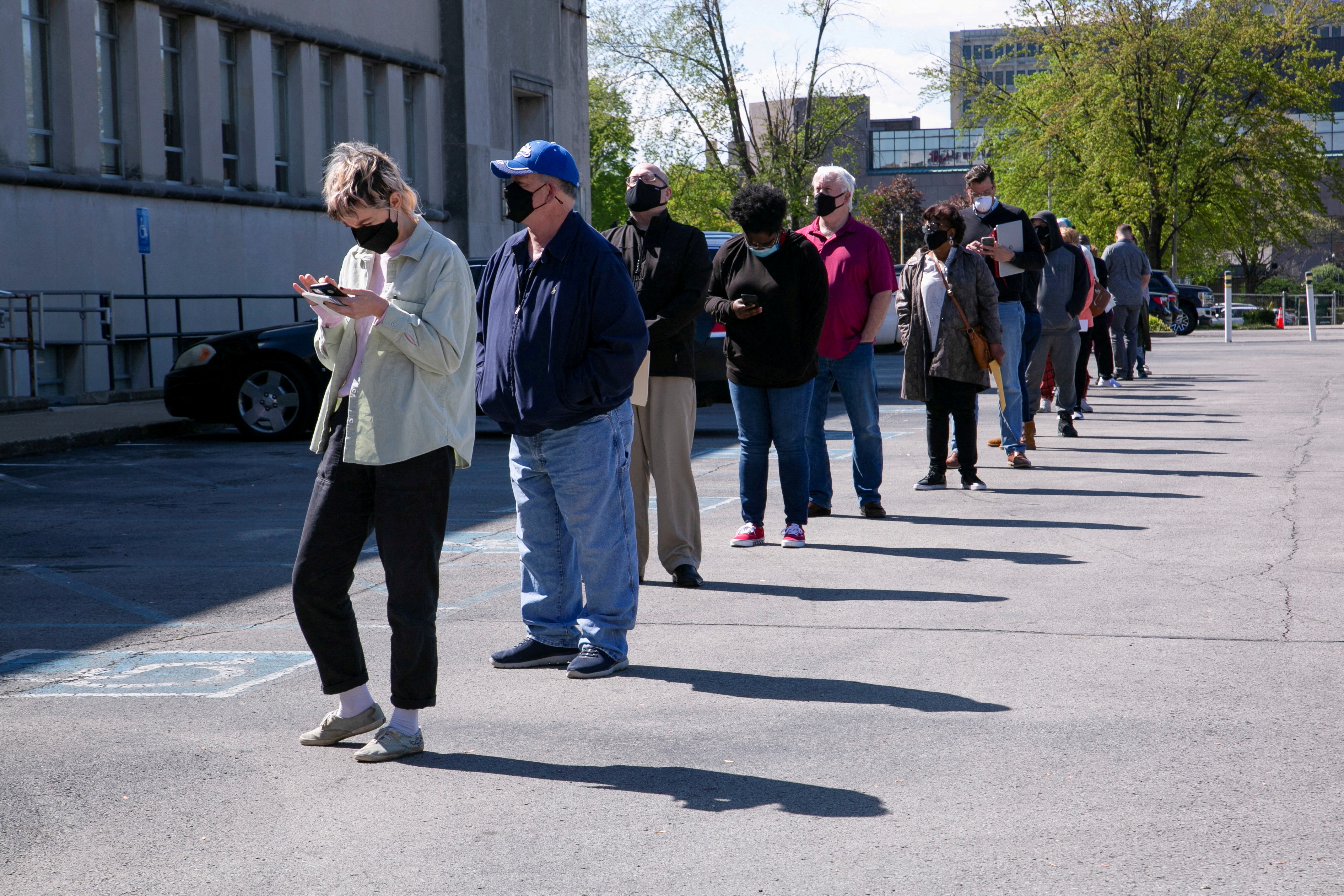 People line up outside a newly reopened career center for in-person appointments in Louisville, Kentucky on April 15, 2021. 