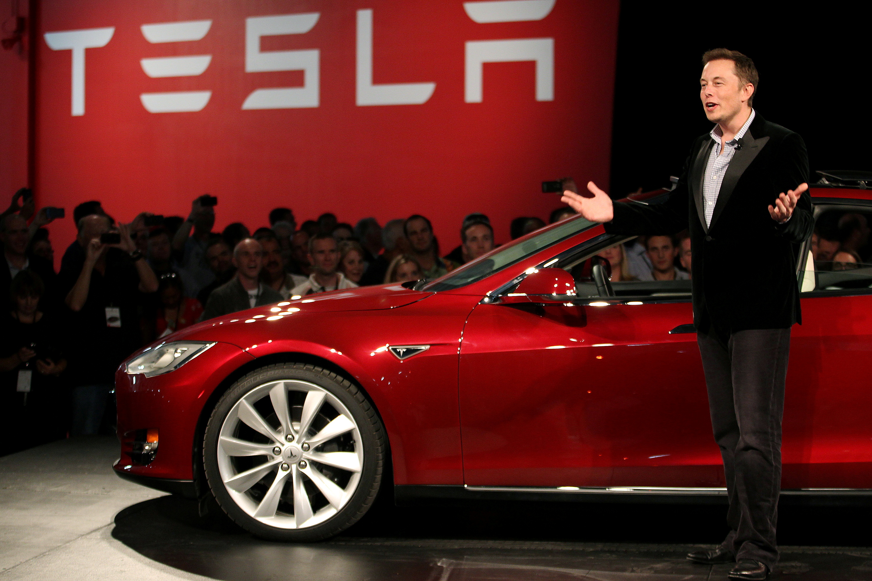Tesla Motors CEO Elon Musk speaks next to the company's newest Model S during the Model S Beta Event held at the Tesla factory in Fremont, California on Oct. 1, 2011.
