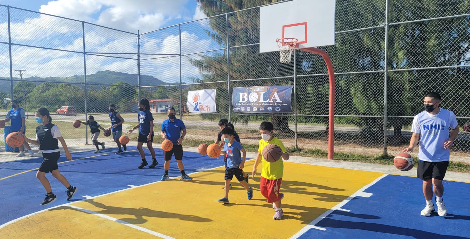 Children practice dribbling drills with volunteers from the NMI Senior National Team program during the “Bola” session at the Kagman Community Center basketball court Saturday.