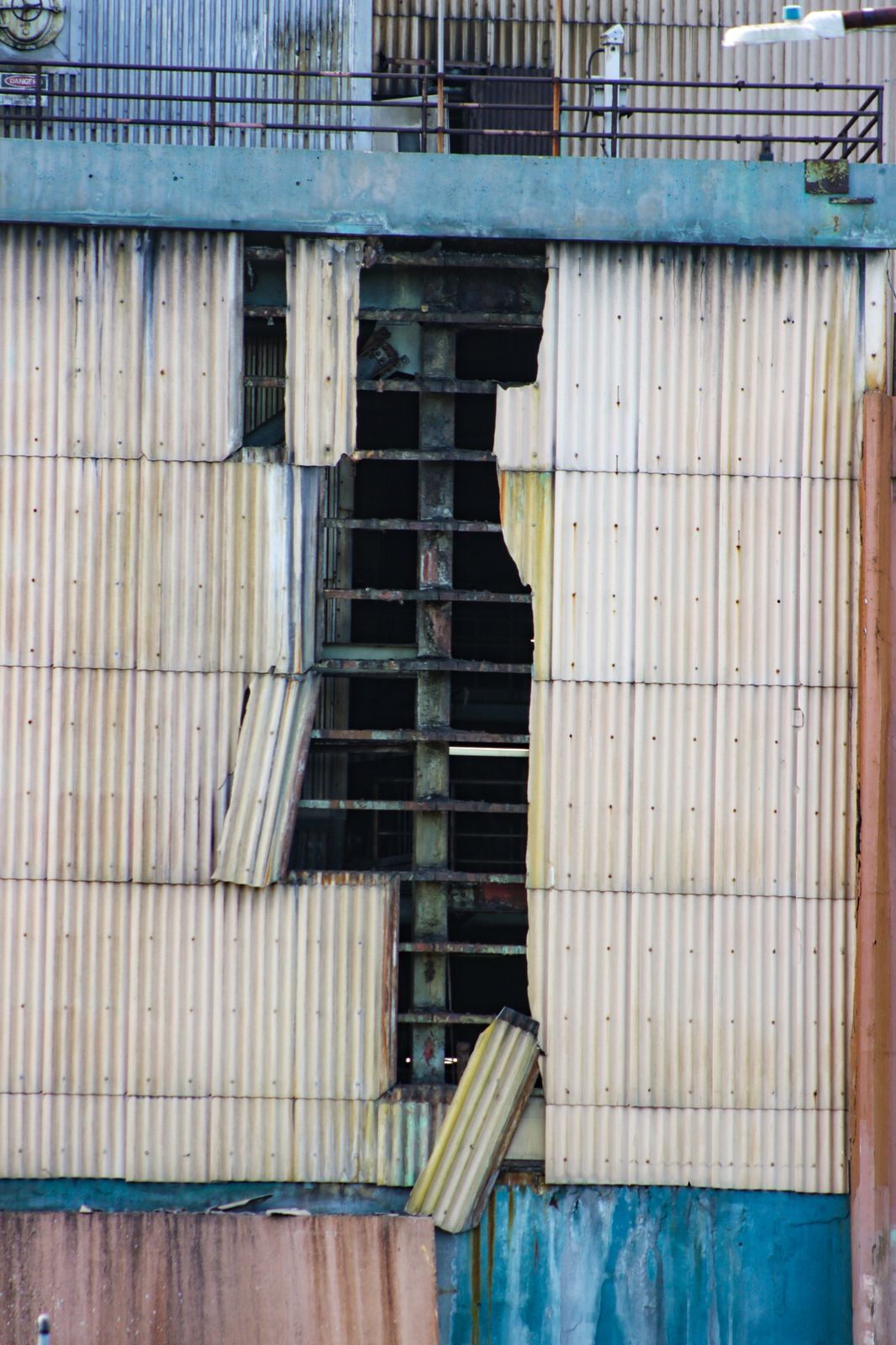 Several panels of the exterior of Cabras 1 have cracked, leaving a hole and exposing what looks like the metal structure of the facility.