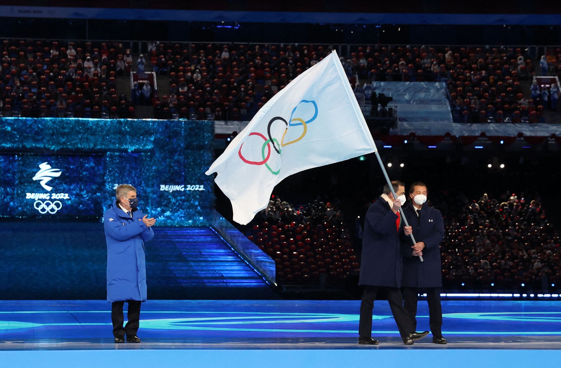 International Olympic Committee  President Thomas Bach hands the Olympic flag to Guiseppe Sala, mayor of Milano City, and Gianpetro Ghedina, mayor of Cortina d'Ampezzo City, Italy during the closing ceremony of the Beijing Olympics at the National Stadium, in Beijing, China on Feb. 20, 2022.