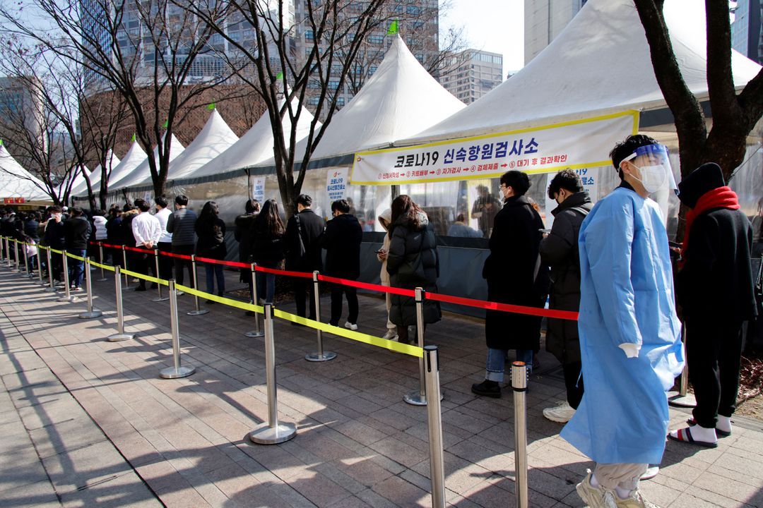 People wait in line to undergo the coronavirus disease test at a temporary testing site set up at City Hall Plaza in Seoul, South Korea, Feb. 10, 2022. 