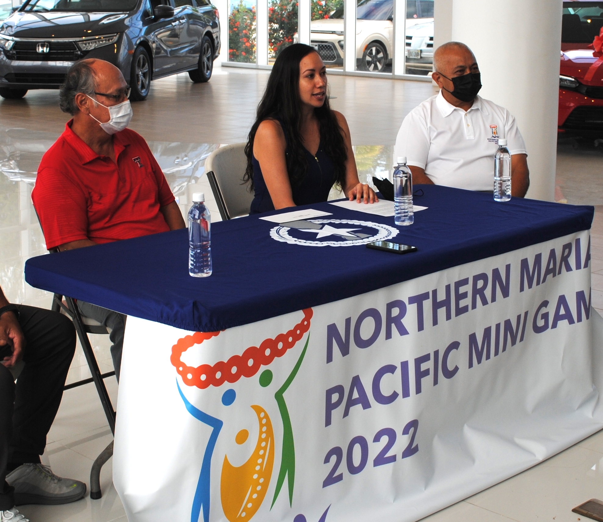 Joeten Daidai Foundation Executive Director Patty Palacios, center, announces their $100,000 donation  as platinum sponsor of the 2022 Pacific Mini Games  in the Joeten Motors showroom Thursday. Also in photo are Norman Tenorio, managing director of Joeten Enterprises, left, and Northern Marianas Pacific Mini Games CEO Vicente "Ben" Babauta, right.