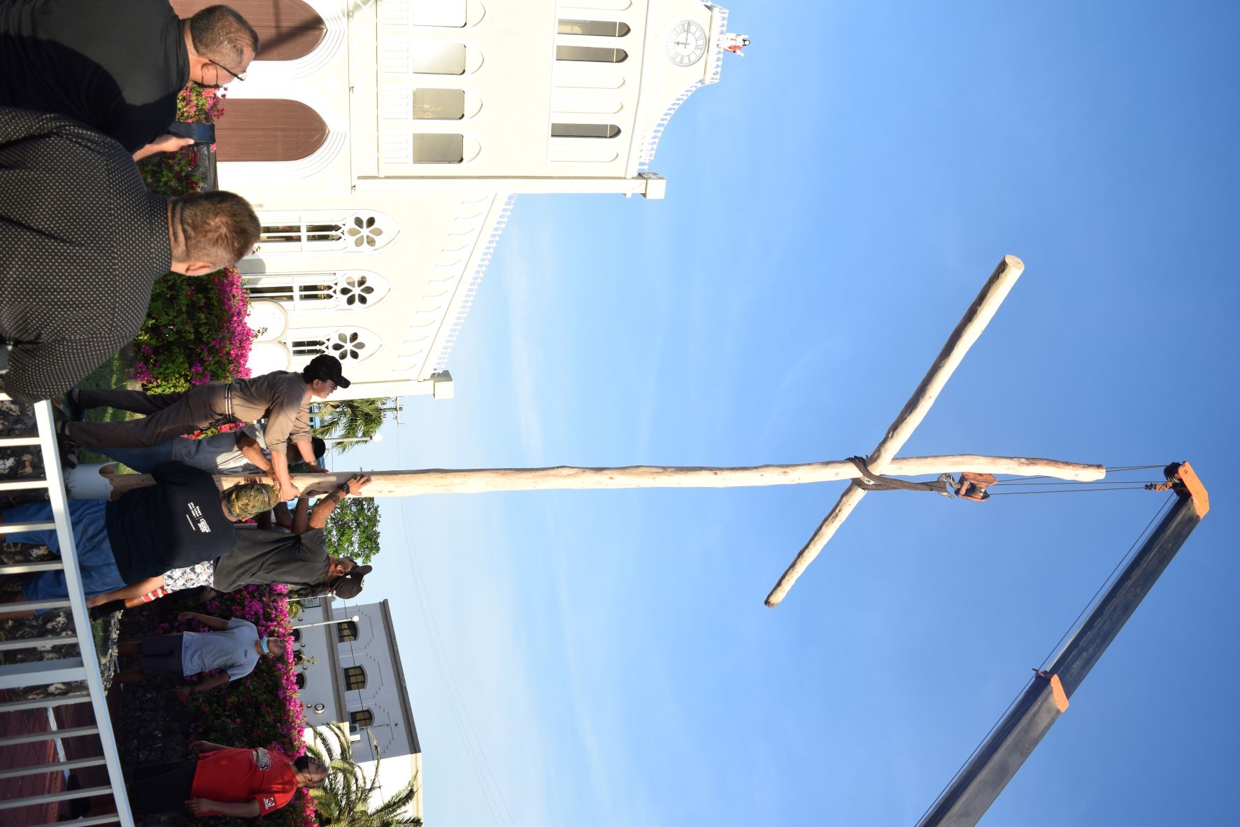 With a help of a crane operator, Tanko clan members erect a cross outside Mt. Carmel Cathedral on Tuesday.
