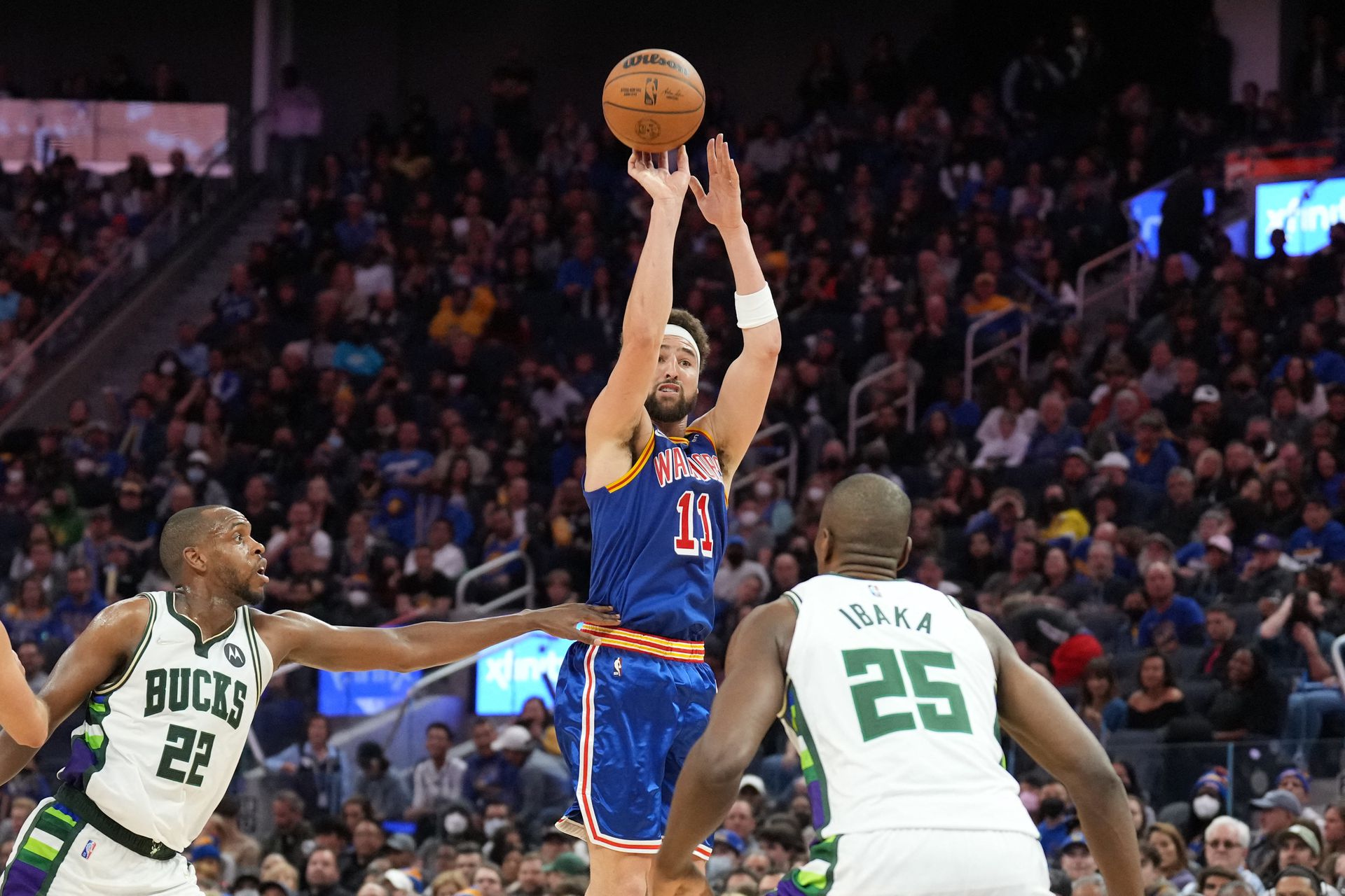 Golden State Warriors guard Klay Thompson (11) shoots against Milwaukee Bucks forward Khris Middleton (22) and center Serge Ibaka (25) during the fourth quarter at Chase Center in San Francisco, California on  March 12, 2022.