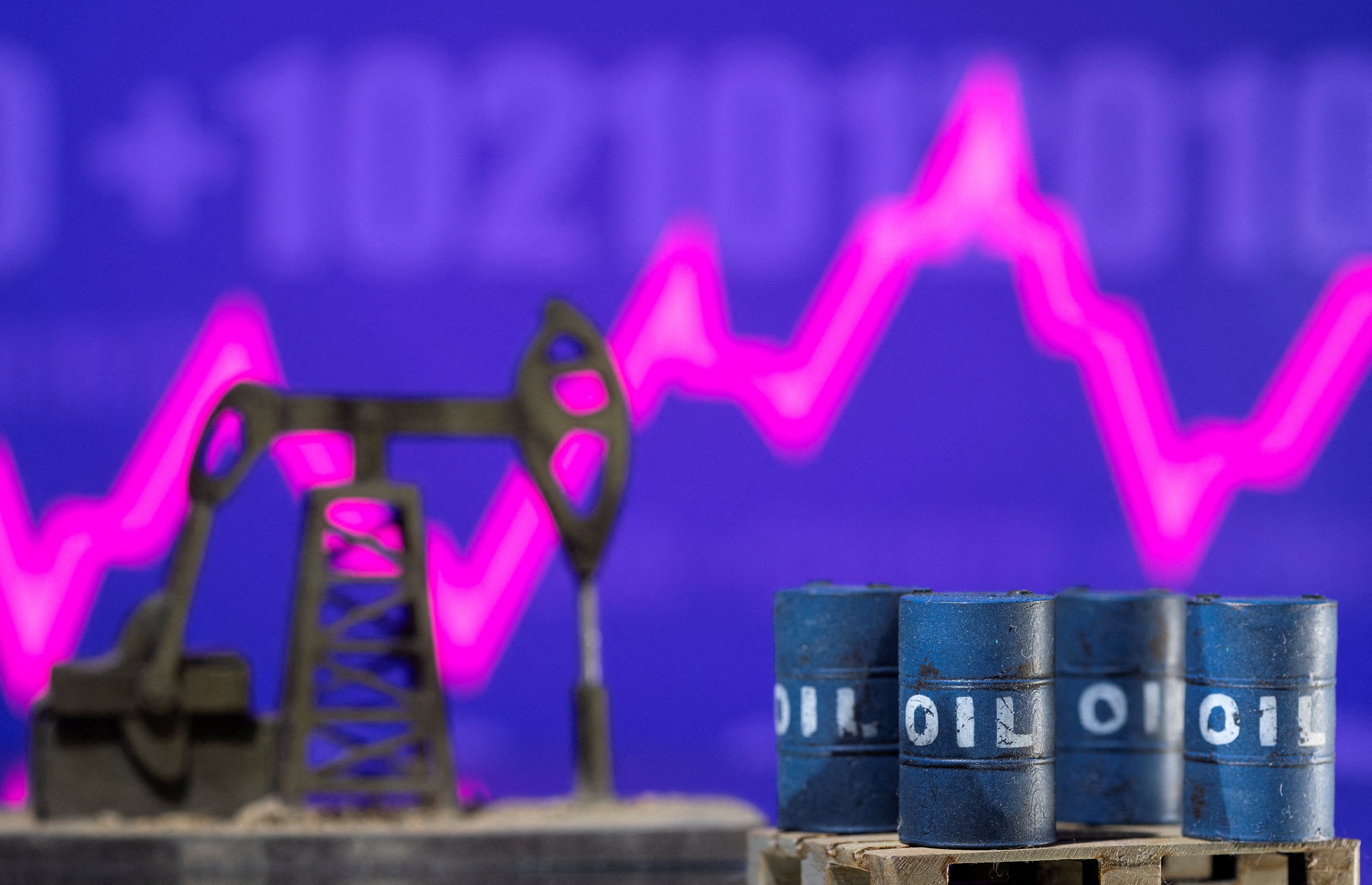 Models of oil barrels and a pump jack are displayed in front of a rising stock graph and "$100" in this illustration taken Feb. 24, 2022.