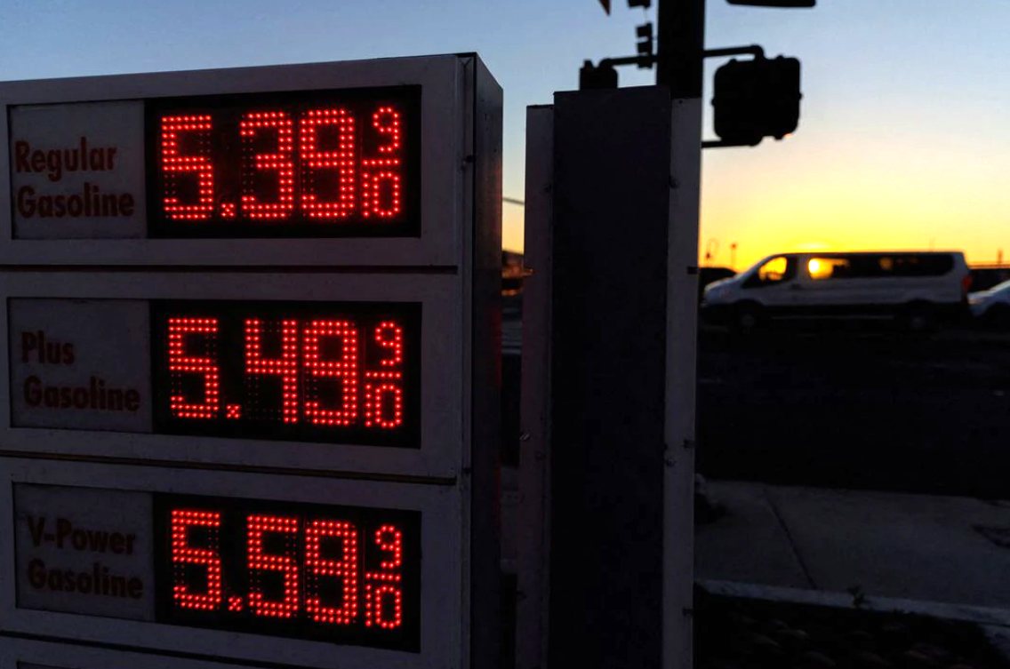 Traffic travels past a sign displaying current gas prices in San Diego, California, Feb. 28, 2022.