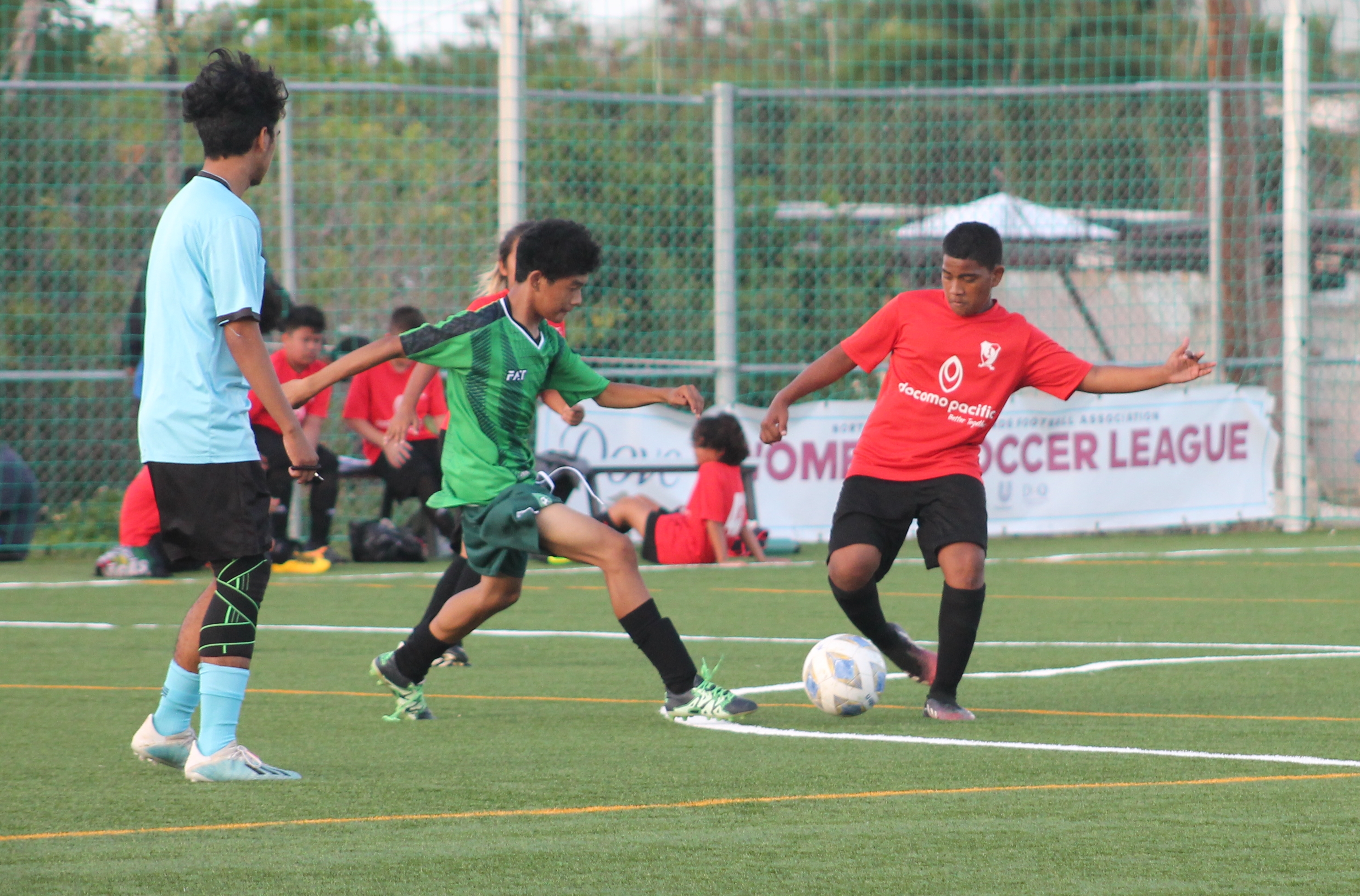 TanHoldings’ Emerson Brillo and Paire’s Angel Demapan battle for the possession during a U13 boys division game of the TakeCare Youth Soccer League on Saturday  at the NMI Soccer Training Center.