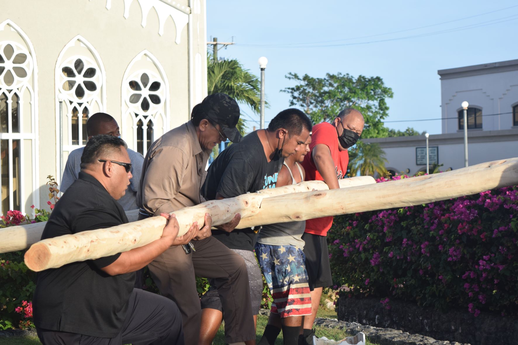 Rep. John Paul Palacios Sablan, right, and other members of the Tanko clan, carry a cross  following a public veneration at Mt. Carmel Cathedral on Tuesday.