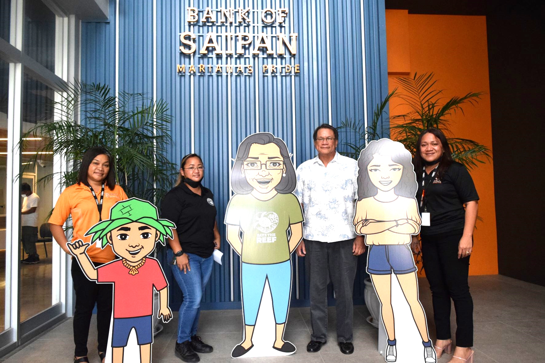 Bank of Saipan President and Chief Executive Officer John Z. Arroyo, second right, BoS Operations Manager Gina Deleon Guerrero, right, script writer and Francisco M. Sablan Middle School teacher Koniko Nakazato, second left, and BoS Loan Manager Karen Kalen, left, pose with life-size cut-outs of Koku, Nana and Kaya at the BoS corporate headquarters on Beach Road, Chalan Laulau Monday.