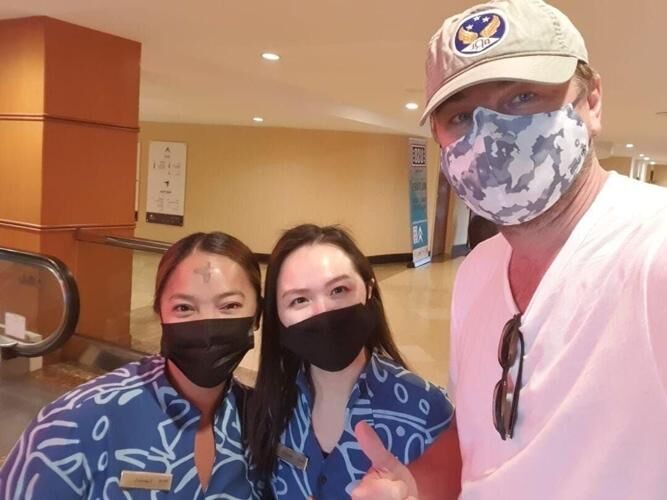 Actor Leonardo DiCaprio takes a photo with two fans at the Dusit Beach Resort in Tumon,  Guam Wednesday.