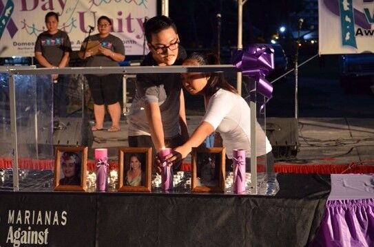 Community members light candles at the 2016 Candlelight Vigil for Domestic Violence Victims to remember and honor the eight CNMI women who passed away due to domestic violence. 