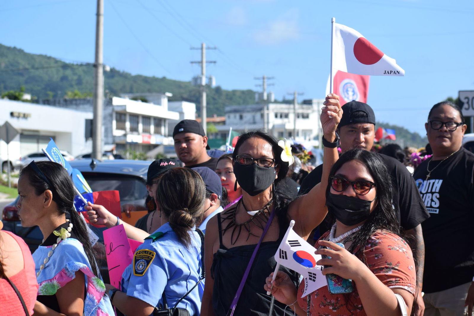 Indigenous cultural advocate Frances M. Sablan holds a small Japanese flag as she joins other women from various cultural groups in a roadside waving activity on the NMI Museum grounds Thursday.