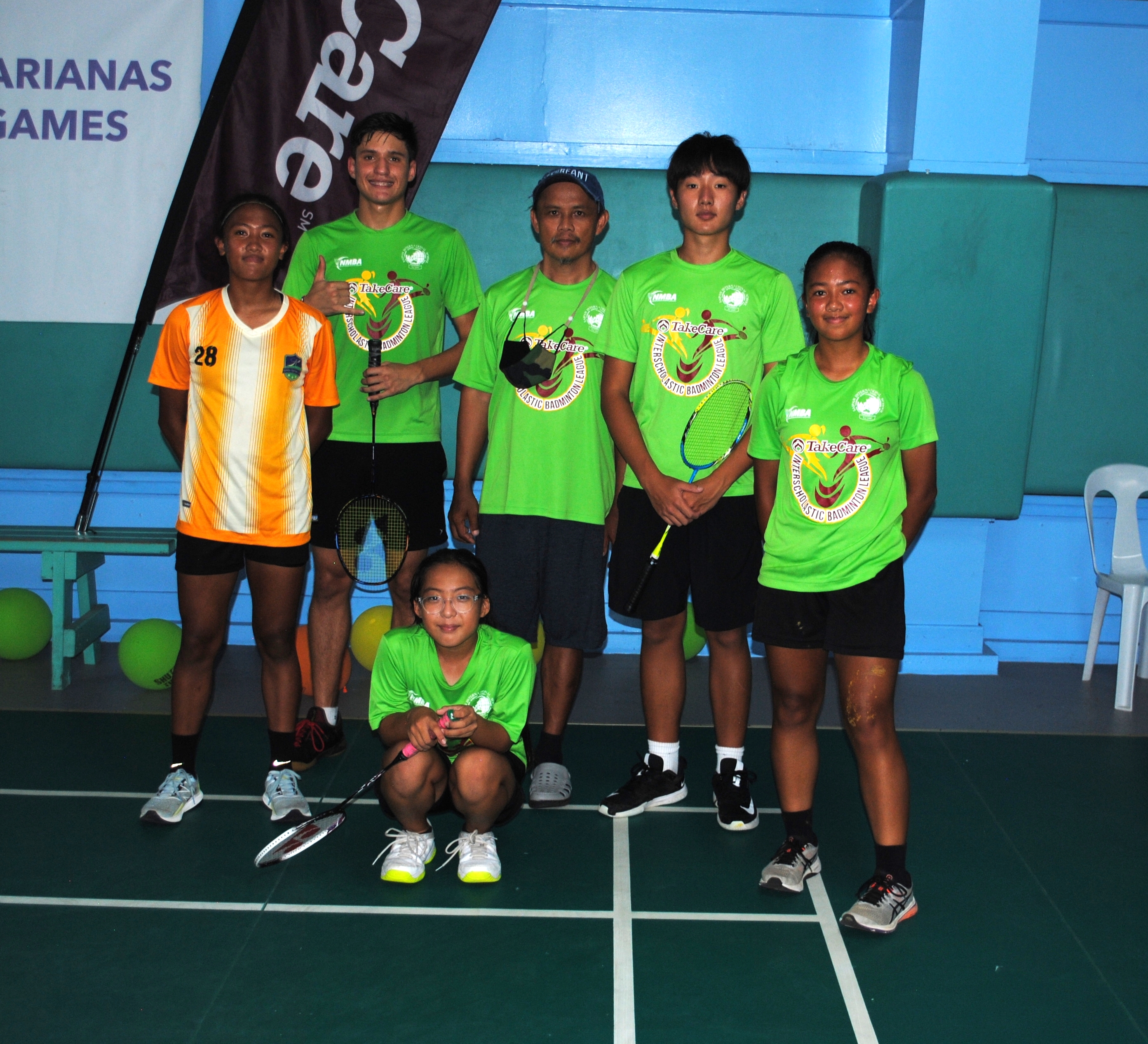 SIS's high school team members pose with coach Fred Guintu before the start of the TakeCare Interscholastic Badminton League championship match at TSL Sports Complex.