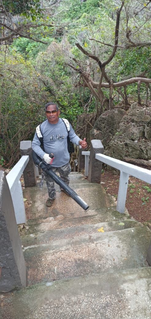 Community volunteer Max Aguon poses for a photo while cleaning up the steps at the Grotto.