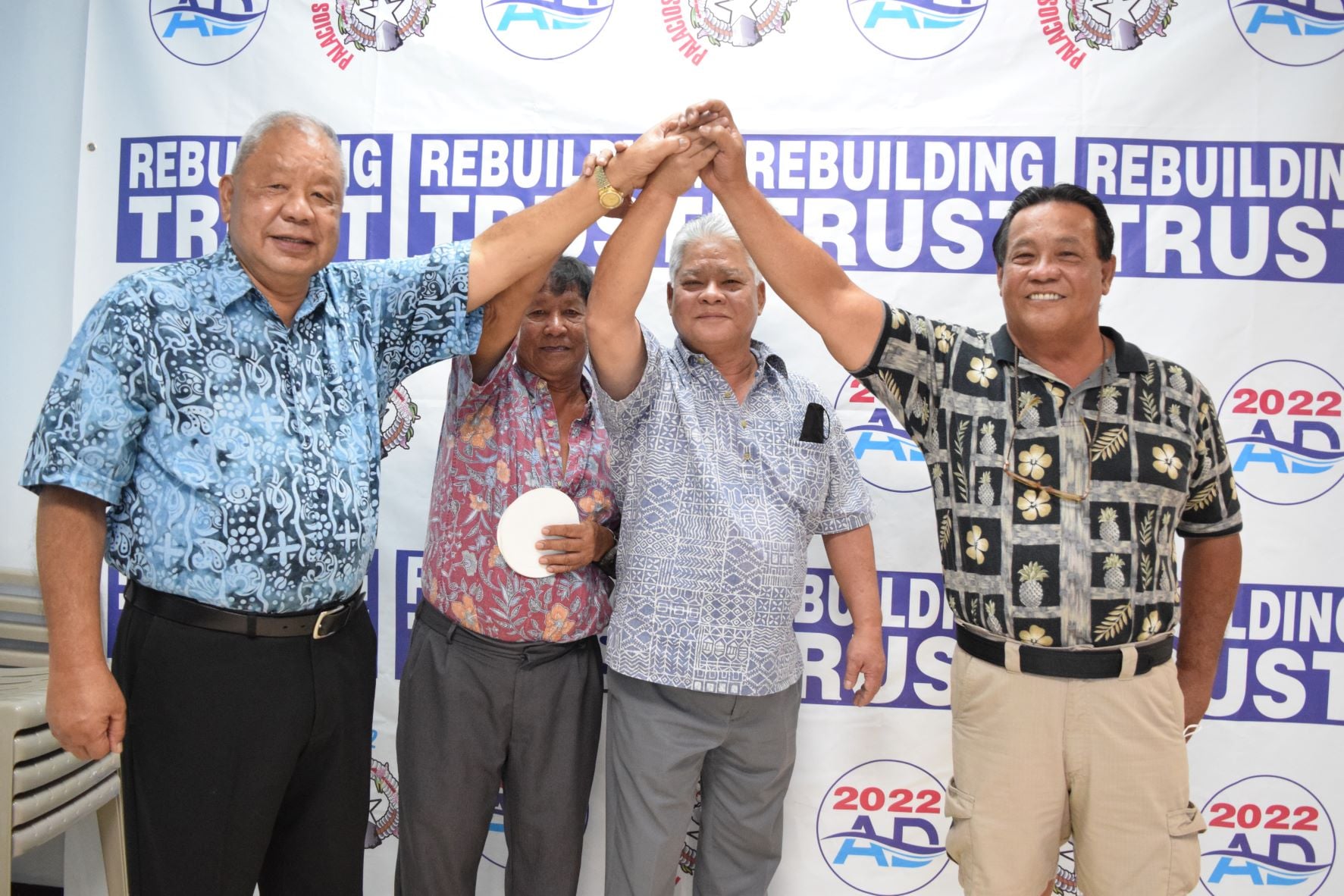 Independent gubernatorial candidate, Lt. Gov. Arnold I. Palacios, second right, and his running mate, Saipan Mayor David M. Apatang, left, join hands with independent Saipan mayoral candidate Ramon "RB" Blas Camacho, right, and his campaign committee chairman, Ray B. Aldan, in the AD 2022 headquarters in Garapan on Friday. 