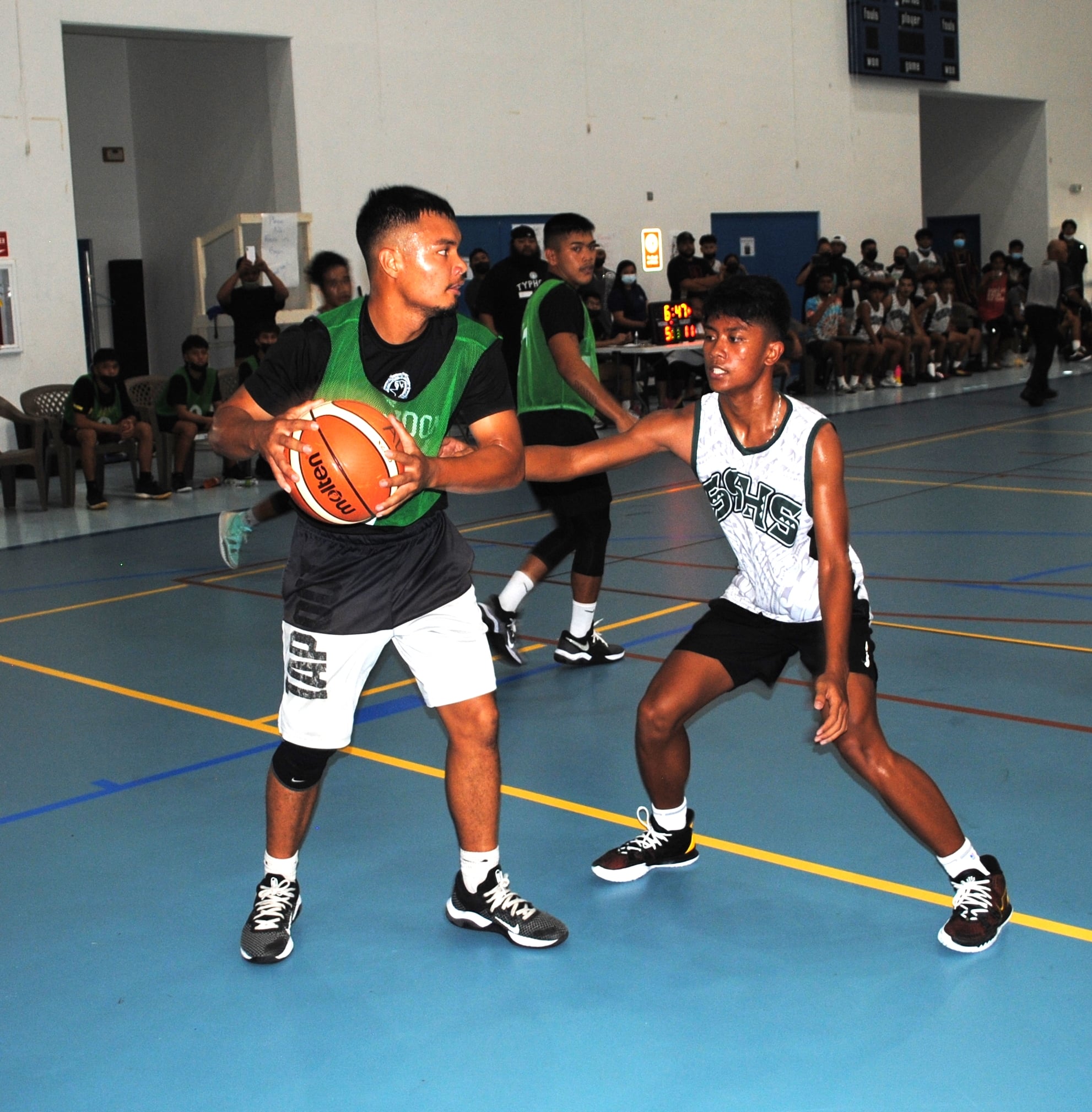 Tinian's Sir Dela Cruz protects the ball as a Saipan Southern High School defender closes in during  Saturday's championship game in the boys high school division of the IT&E Interscholastic Basketball League at the MHS gym.