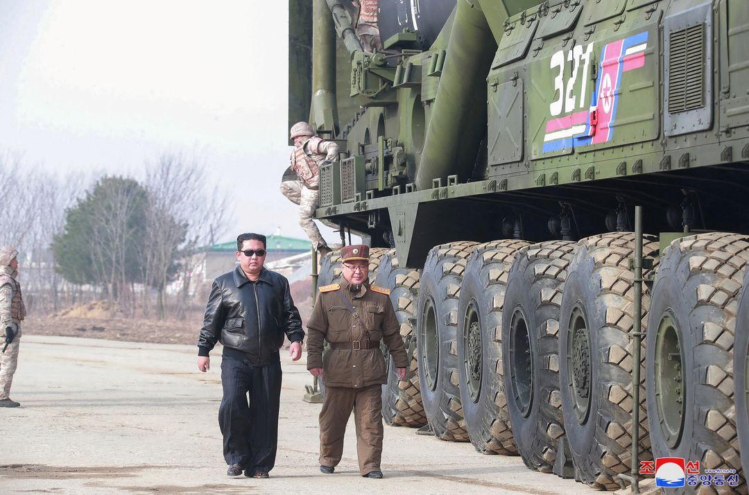 North Korean leader Kim Jong Un walks next to what state media reports is the "Hwasong-17" intercontinental ballistic missile on its launch vehicle in this undated photo released on March 25, 2022 by North Korea's Korean Central News Agency.