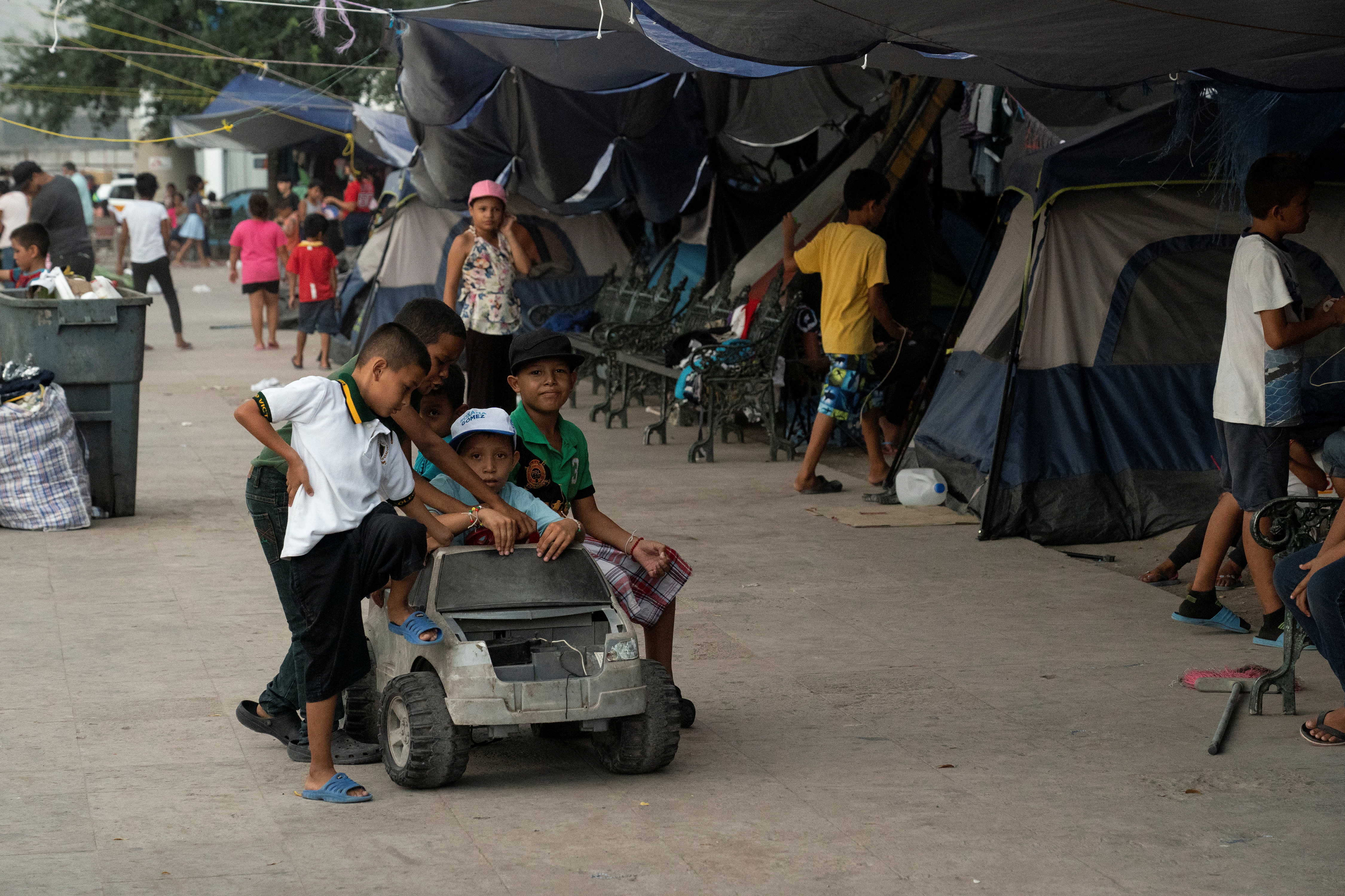 Asylum-seeking migrant children from Central America, who were sent back to Mexico under Title 42 after crossing the border into the U.S. from Mexico, play with a toy car in the public square where hundreds of migrants live in tents, in Reynosa, Mexico, Aug. 27, 2021. 