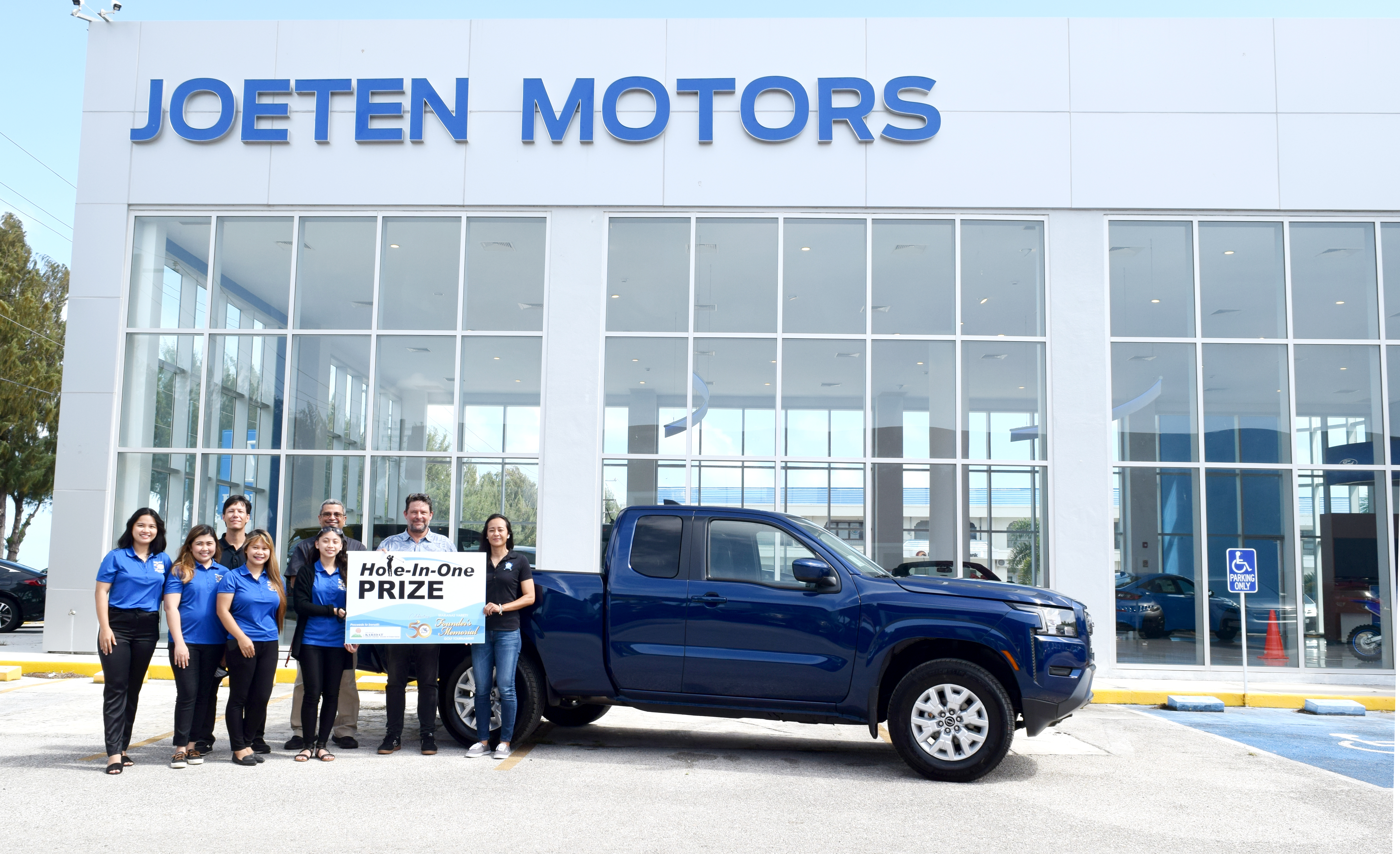 Joeten Motors Chief Financial Officer Somia Quan, right, Operations Manager Peter "Dung" Tenorio, third left, General Manager Matt Deets, second right and Sales Manager Boss Alvarez, third right,  back row, pose for a photo with Marianas Variety sales representatives Hazel Sadian, Gwendolyn Sandig, Diane Lumapas and Monique Mascarinas during a presentation of Joeten Motors’ hole-in-one prize donation for the Marianas Variety Founder's Memorial Golf Tournament set for Saturday, April 2 at 6 a.m., LaoLao Bay Golf & Resort, West Course. The event aims to raise funds for the charitable organization Karidat.