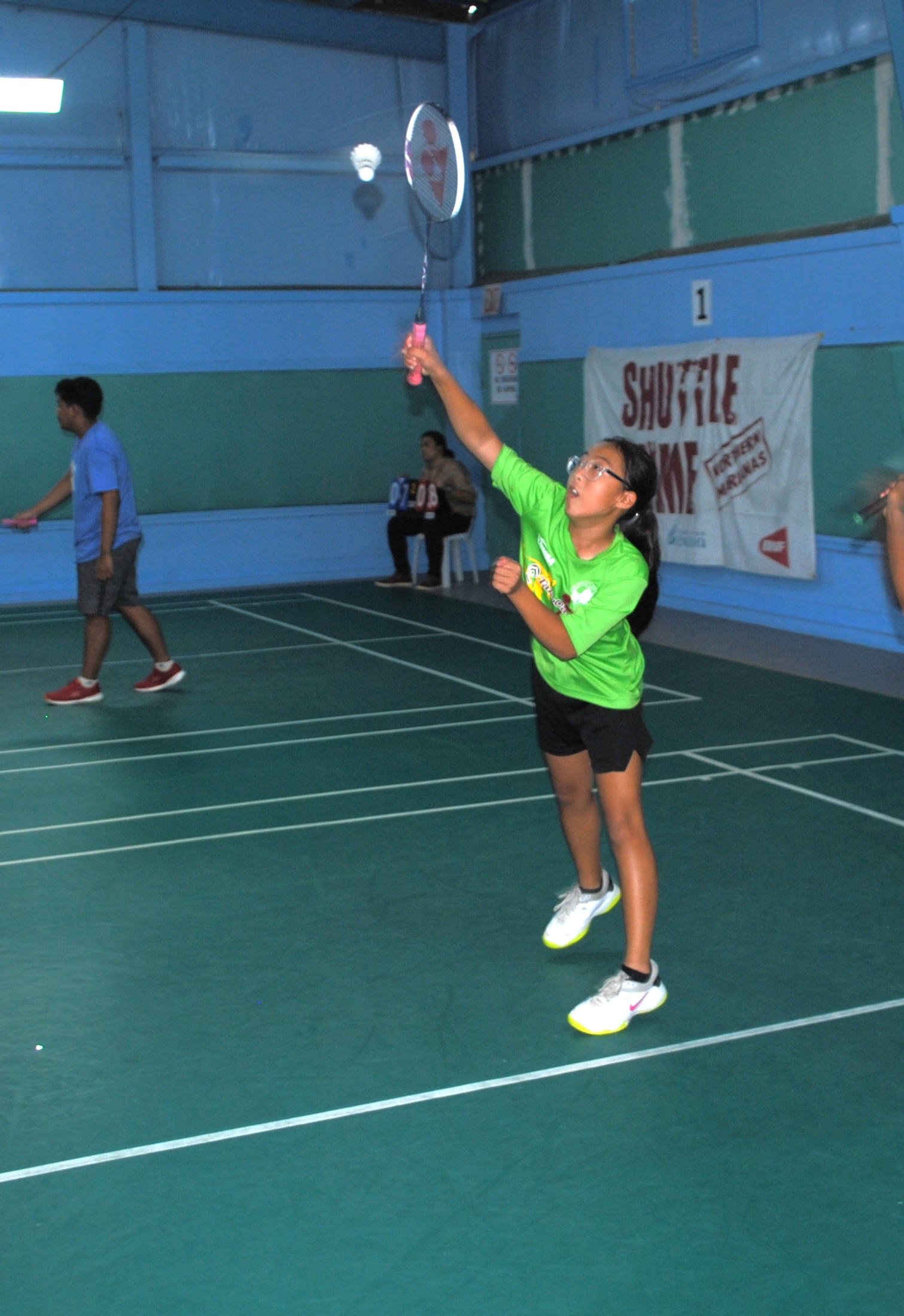 SIS' Lina Takugoshi extends for the overhand return during the girls doubles championship match of the TakeCare Interscholastic Badminton League at the TSL Sports Complex.