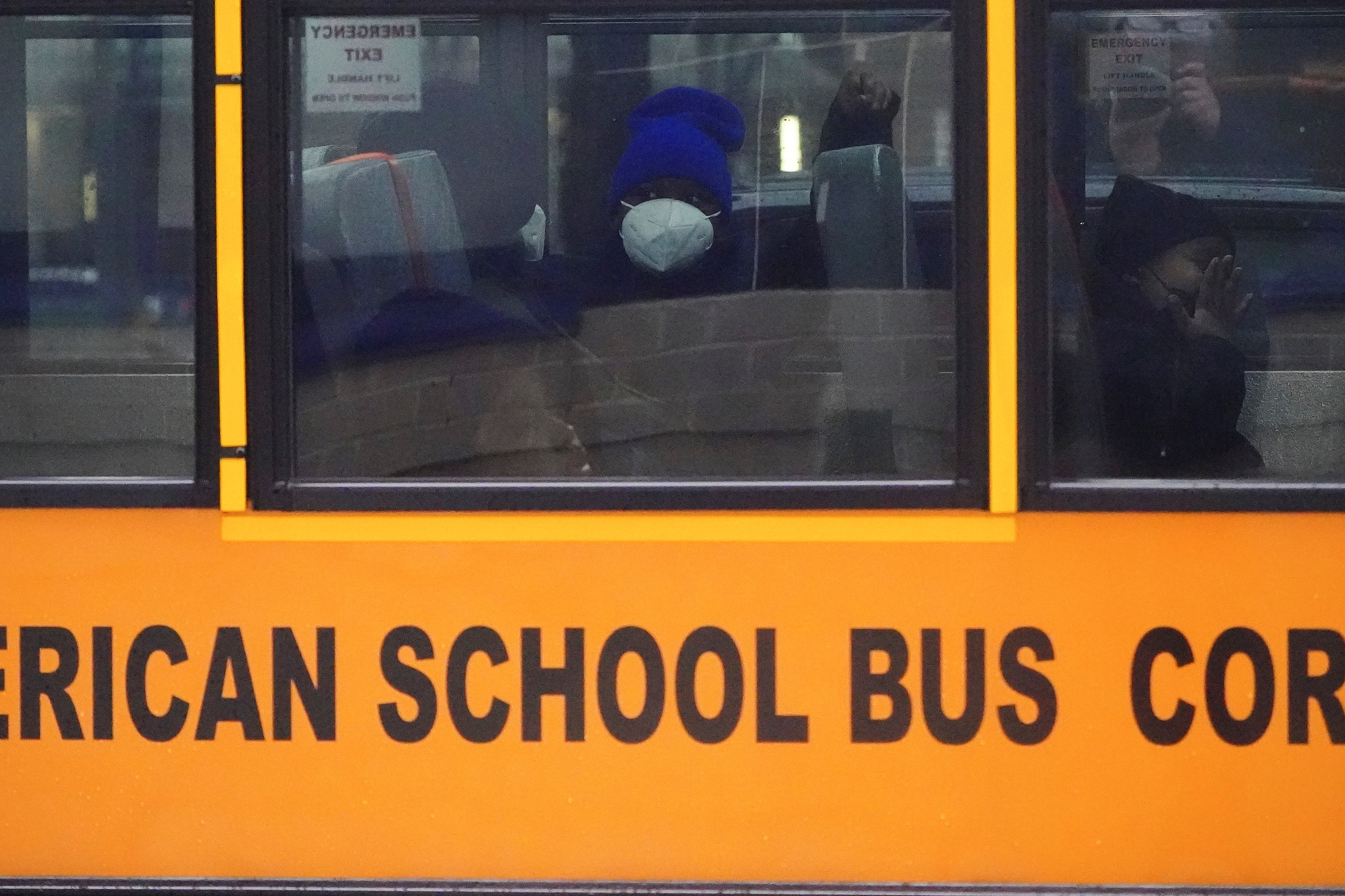 A child wearing a face mask arrives at school in a bus in the Manhattan borough of New York City, New York on Jan. 5, 2022. REUTERS