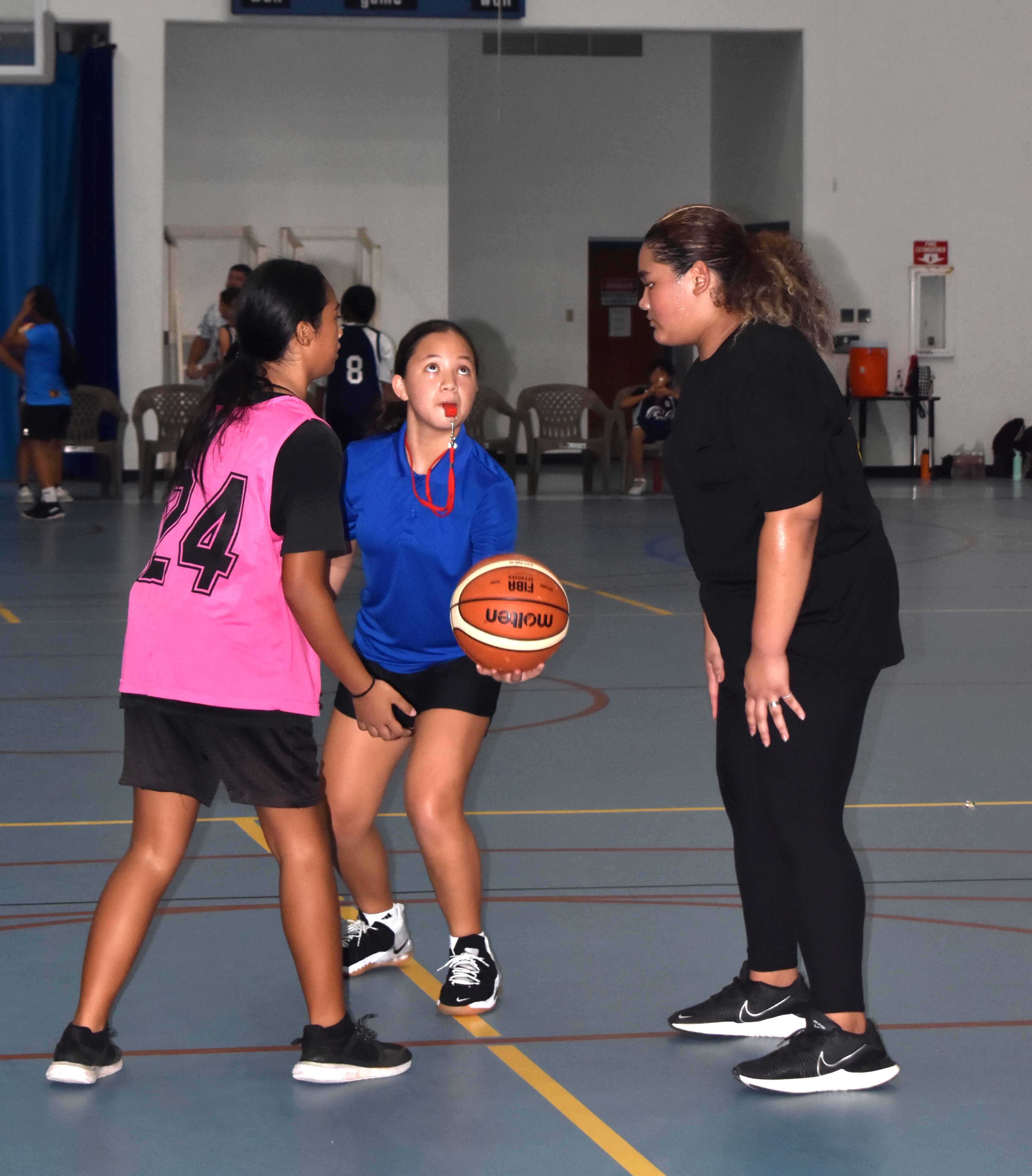 Destiny Pangelinan, center, is about to toss the ball in the game between Dandan Middle School and Tanapag Middle School in the IT&E Interscholastic Girls Middle School Basketball League late last year at the Marianas High School Gymnasium.