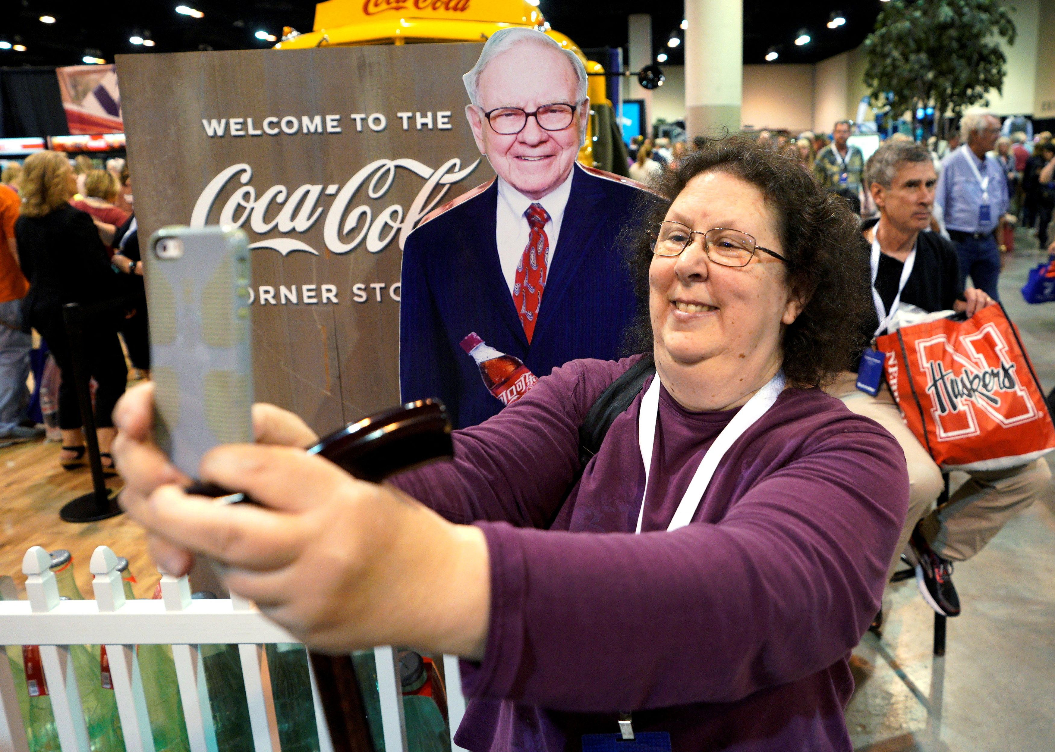 A shareholder takes a selfie with a picture of Warren Buffett at the Berkshire Hathaway Inc annual meeting, the largest in corporate America, in its hometown of Omaha, Nebraska on May 4, 2018.
