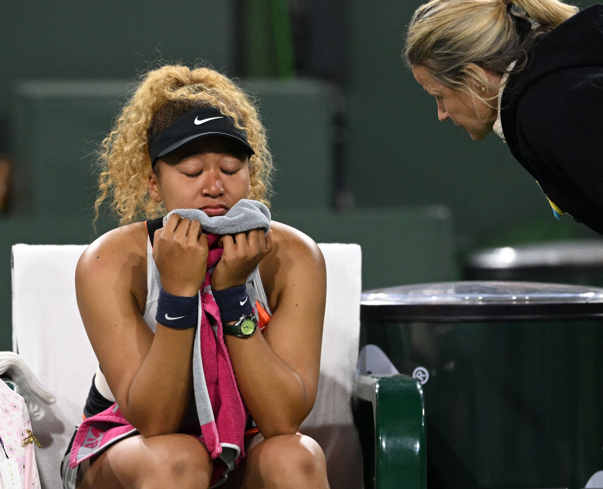 Naomi Osaka wipes her face as she talks to referee Claire Wood after a spectator disrupted play, yelling “Naomi you suck,” before the start of her 2nd round match against Veronika Kudermetova at the BNP Paribas open at the Indian Wells Tennis Garden on March 12, 2022 in Indian Wells, California.