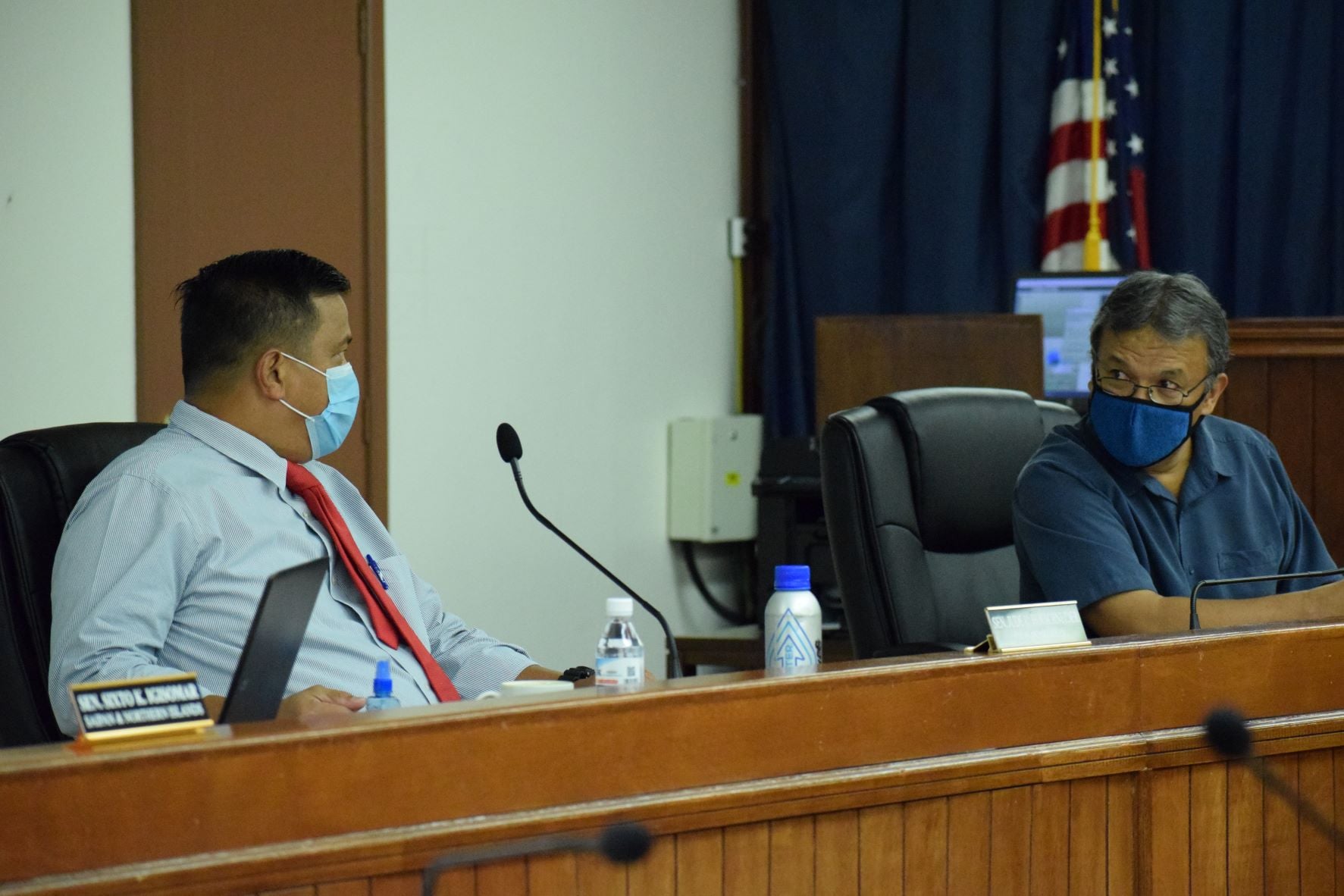 Senate President Jude U. Hofschneider, left, talks with Sen. Paul A. Manglona during a break from a session in this file photo.