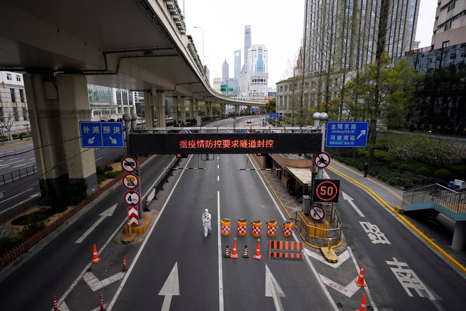 A worker in a protective suit walks at an entrance to a tunnel leading to the Pudong area across the Huangpu river in Shanghai, China on March 28, 2022.