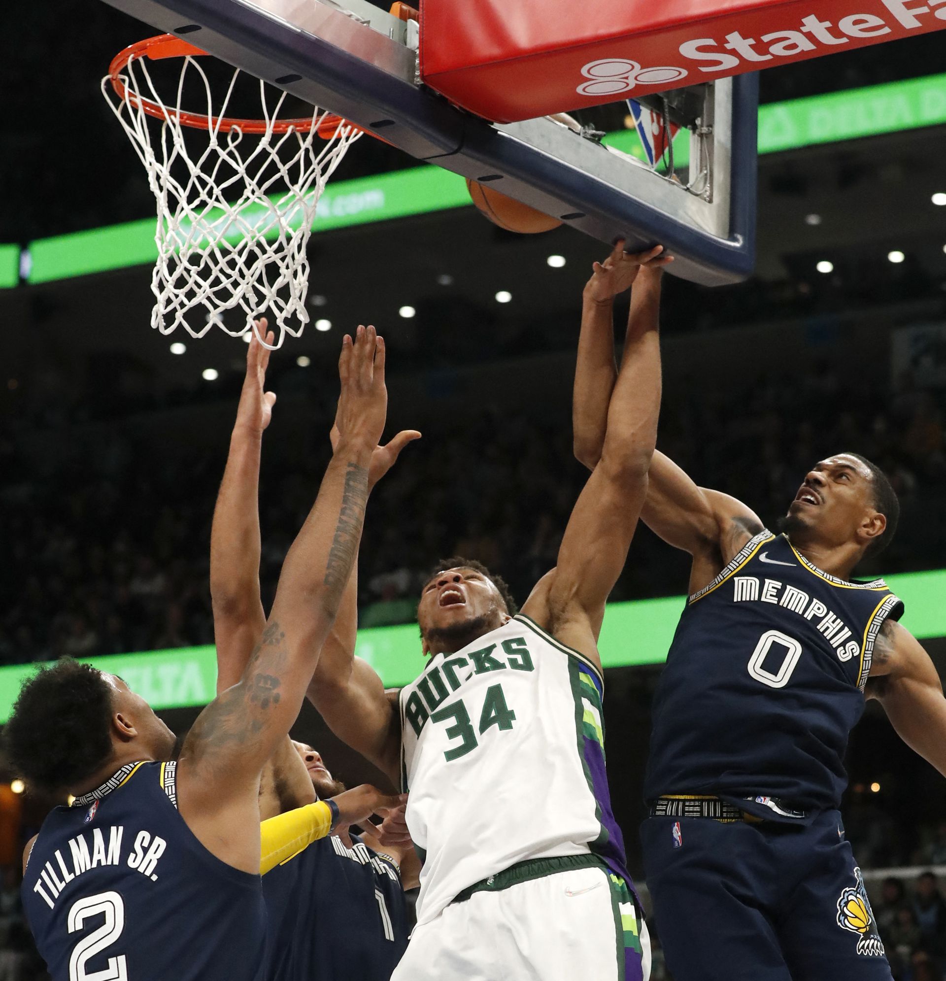 Milwaukee Bucks forward Giannis Antetokounmpo (34) shoots the ball against Memphis Grizzlies center Xavier Tillman (2) and guard De'Anthony Melton (0) during the second half at FedExForum in Memphis, Tennessee on March 26, 2022.