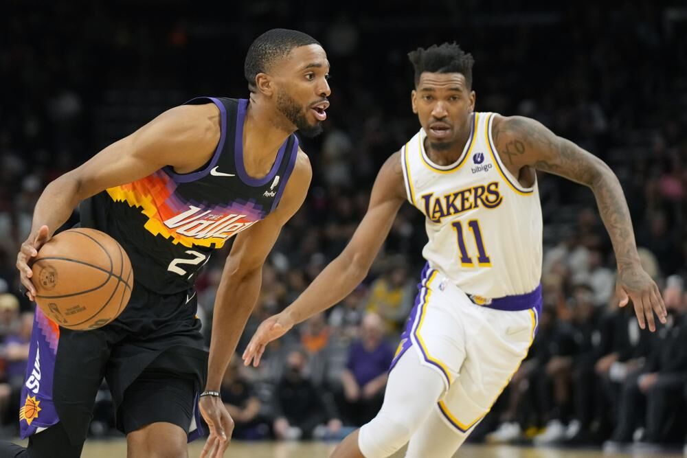 Phoenix Suns forward Mikal Bridges, left, drives past Los Angeles Lakers guard Malik Monk, right, during the second half of an NBA basketball game, Sunday, in Phoenix.
