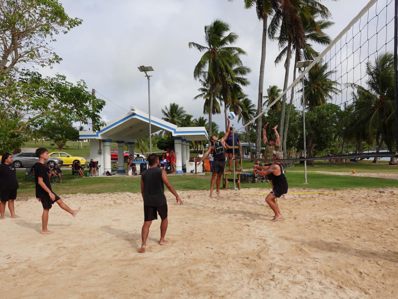 David Mediola spikes as Cody Kramer, in black, and a teammate defend during the Beach Vollyeball Contest on March 12, 2022, at the 18th  Annual Tinian Hot Pepper Festival in San Jose, Tinian.