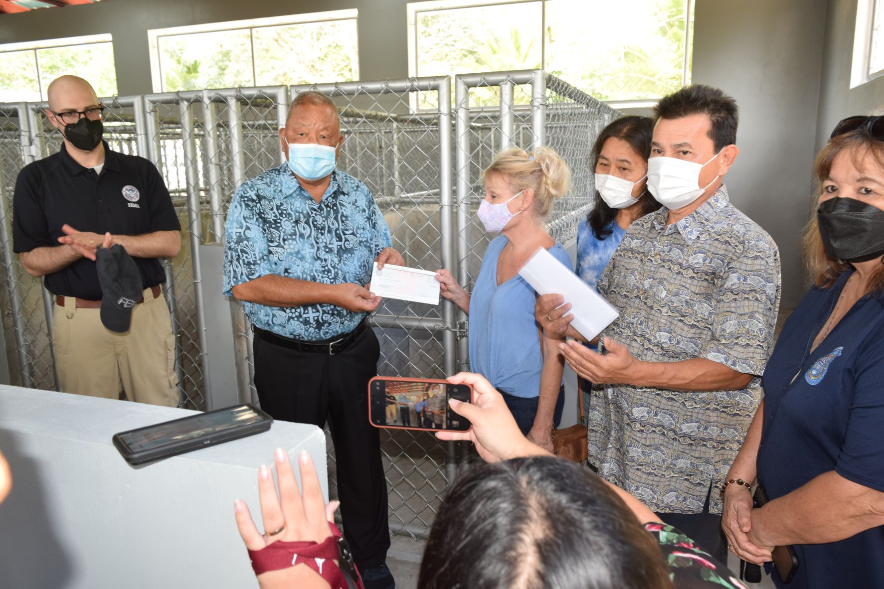Saipan Mayor David M. Apatang, second left, hands Saipan Cares of Animals Director Elizabeth Pliscou, center, a check for $10,000 as Federal Emergency Management Agency Region 9 Recovery Division Director Robert M. Pesapane applauds during a presentation at the newly completed multi-function animal shelter facility in As Perdido on Wednesday. Also in photo are the special assistant to the mayor, Henry Hofschneider, second right; Saipan Mayor's Office budget officer Teri Camacho, right; and Saipan Cares vice president Yumiko Brundidge.