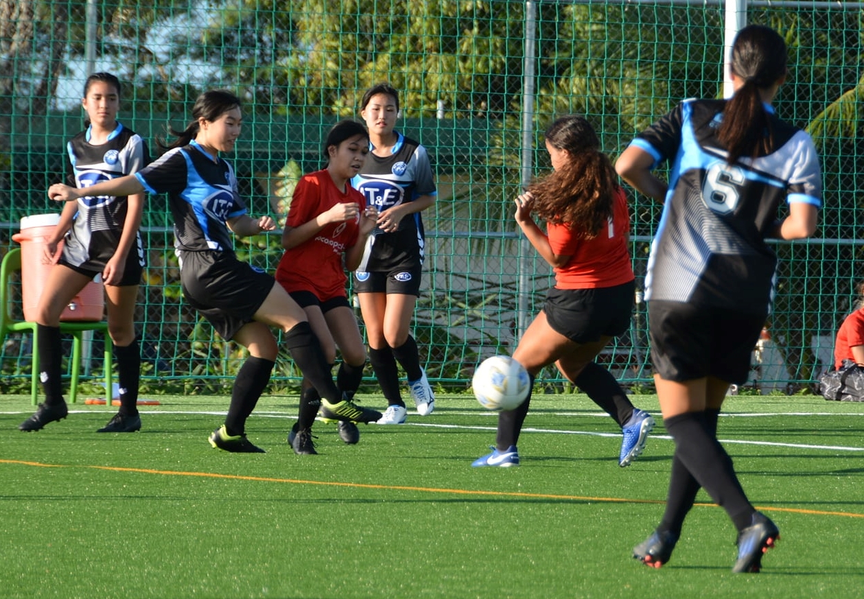 MP United and Kanoa players battle for the possession during a U16 girls division game of the TakeCare Youth Soccer League Saturday at the NMI Soccer Training Center.