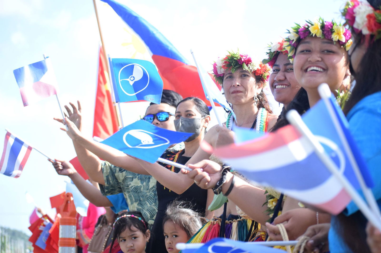 First lady Diann Torres and other women representing different cultural groups participate in a roadside waving activity on the NMI Museum grounds Thursday.